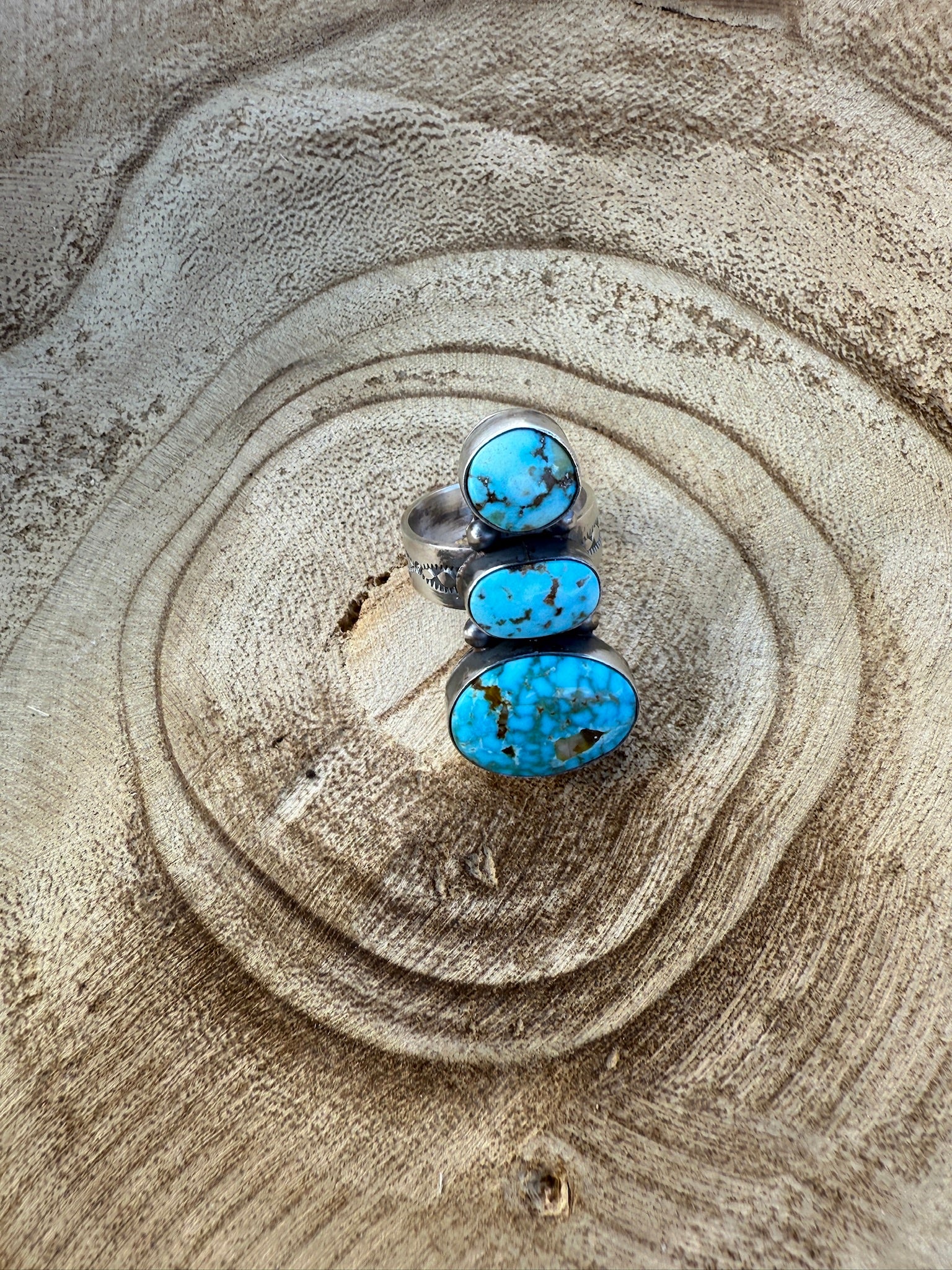 Turquoise stone on a wooden surface with concentric circular patterns