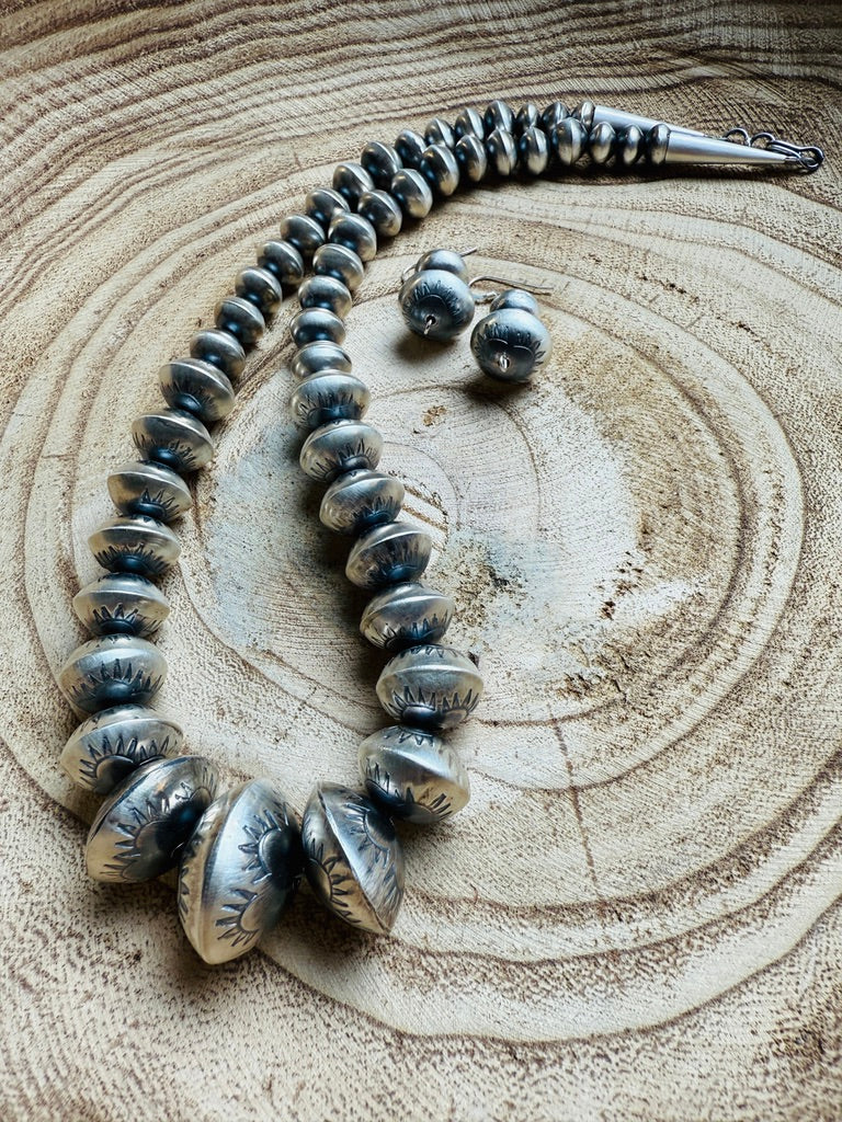 Silver necklace and earrings on a wooden surface