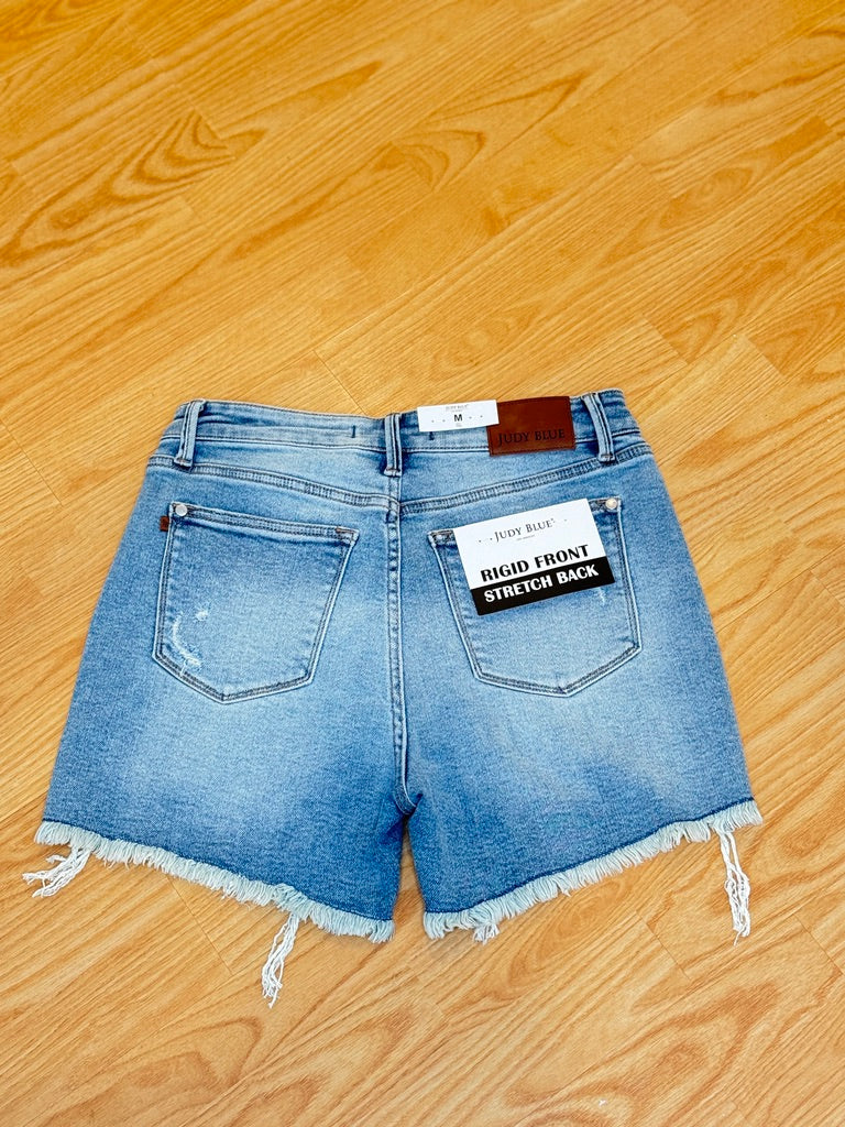 Pair of denim shorts on a wooden floor