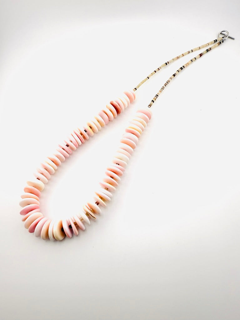 Necklace with pink and beige beads on a white background