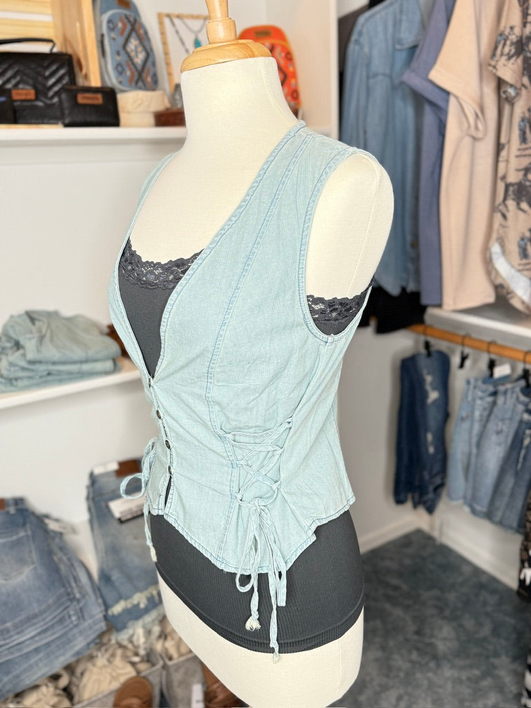 Light blue denim top with lace trim on a mannequin in a clothing store setting.