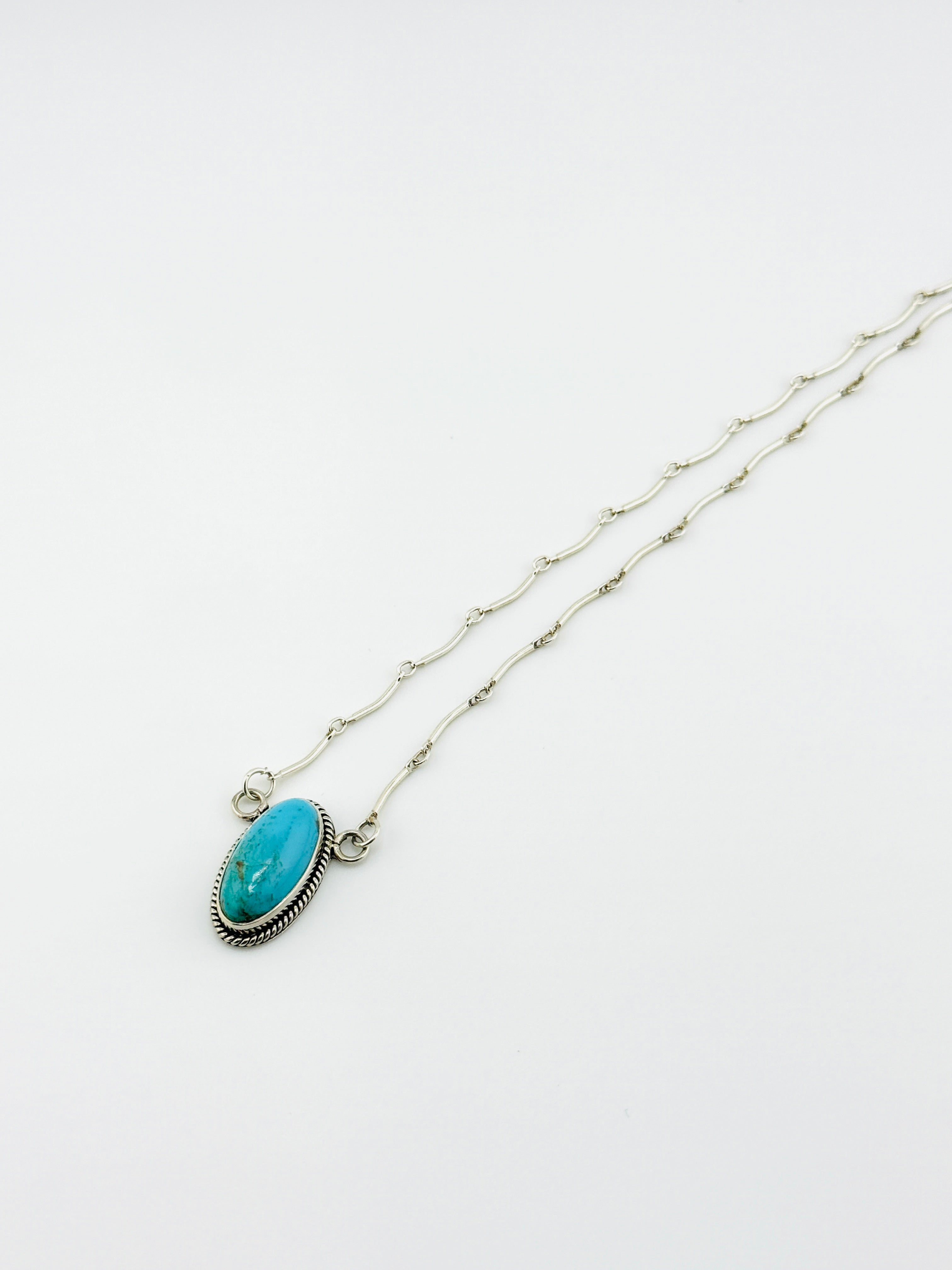 Necklace with a turquoise pendant on a white background