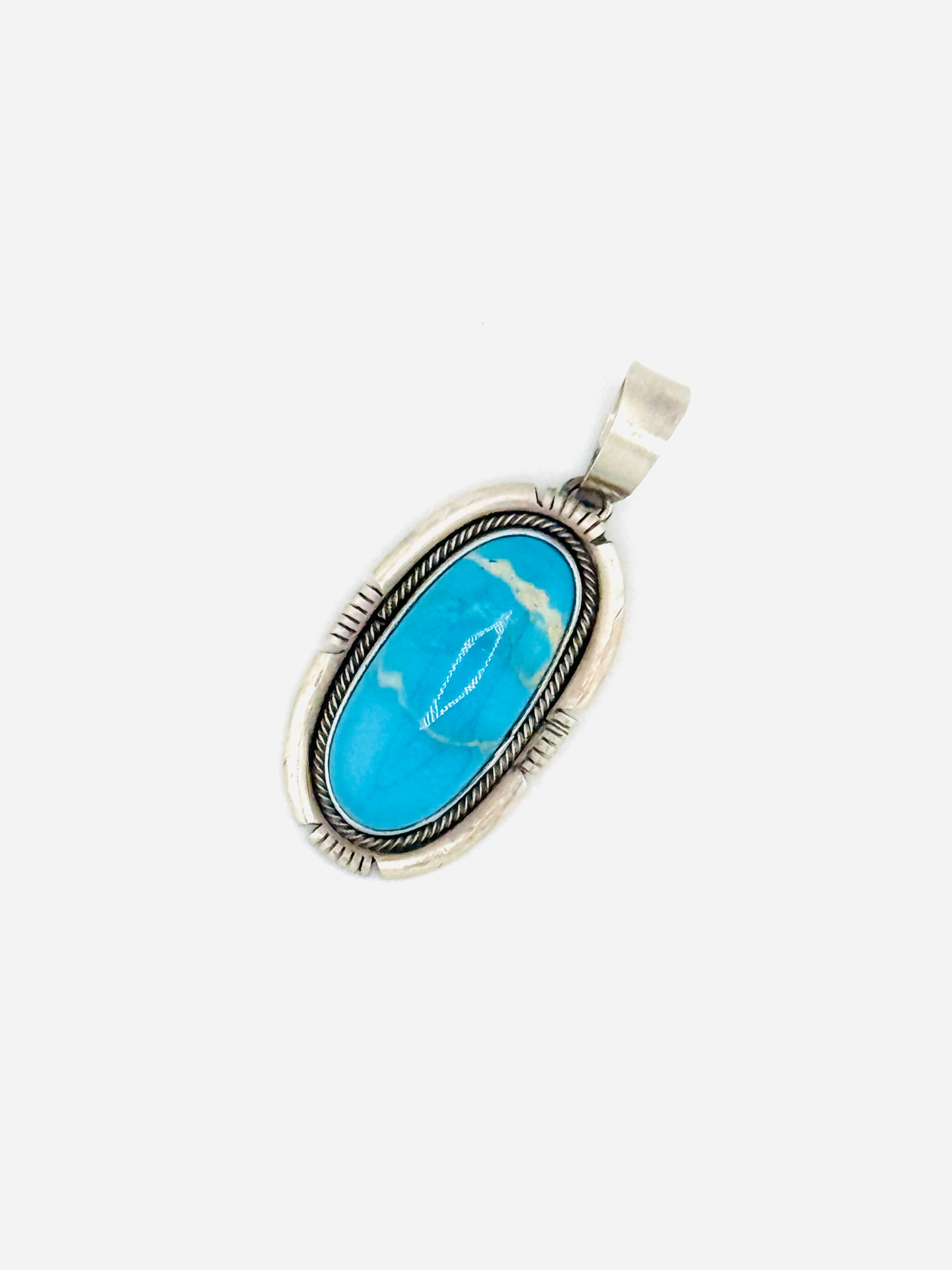 Turquoise stone pendant with silver frame on a white background