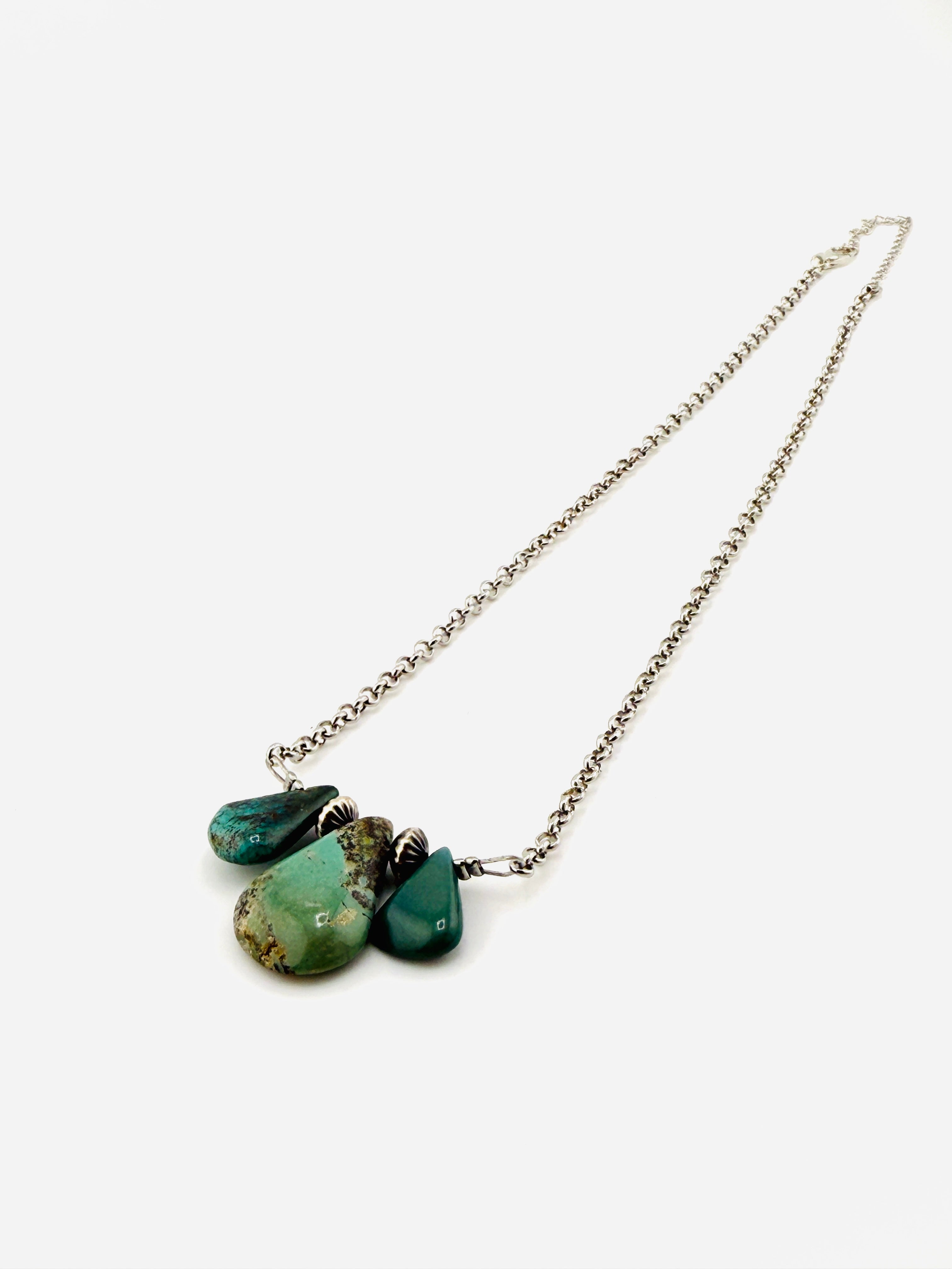 Necklace with green stone pendants on a white background