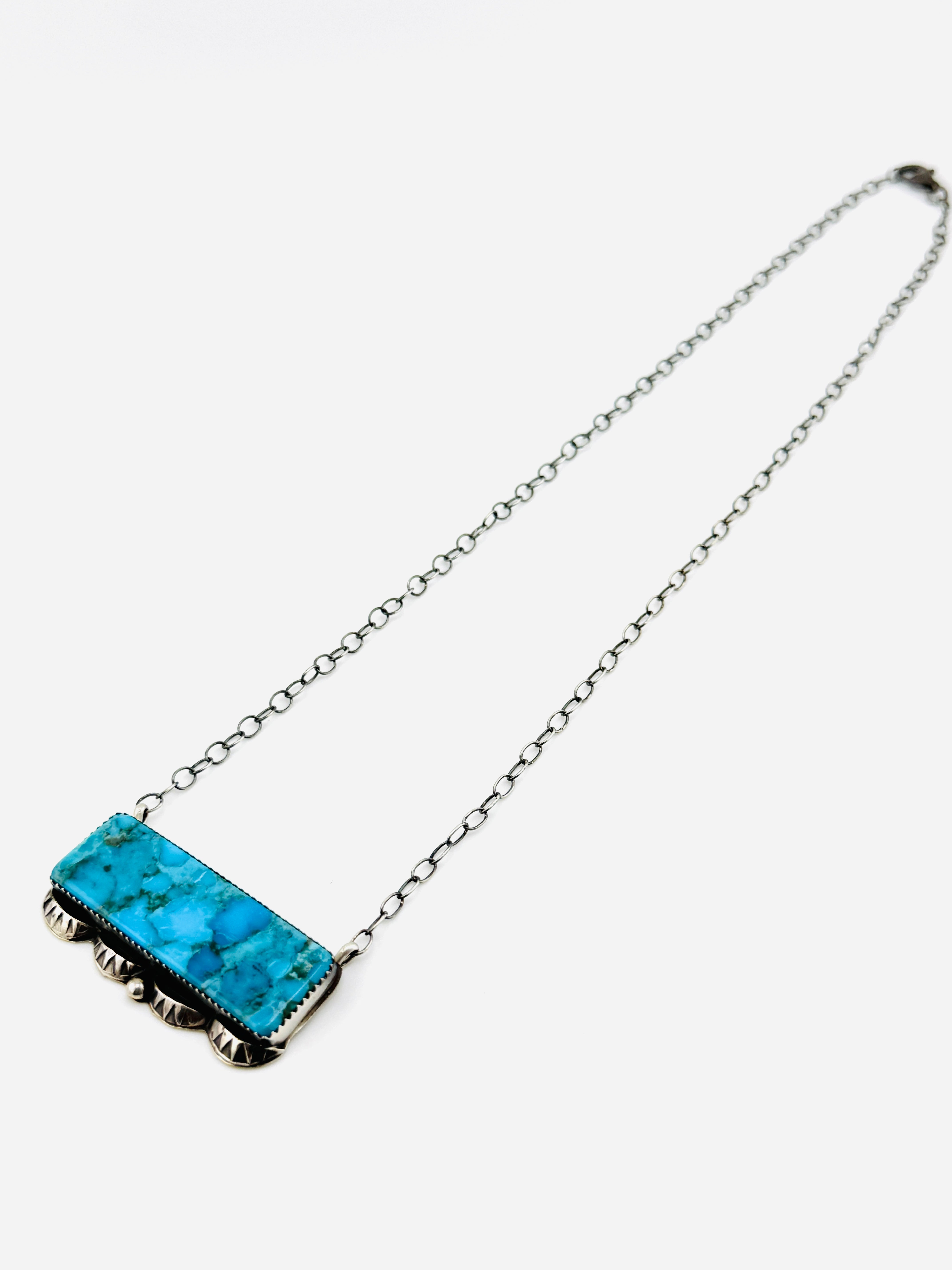 Necklace with a blue stone pendant on a white background