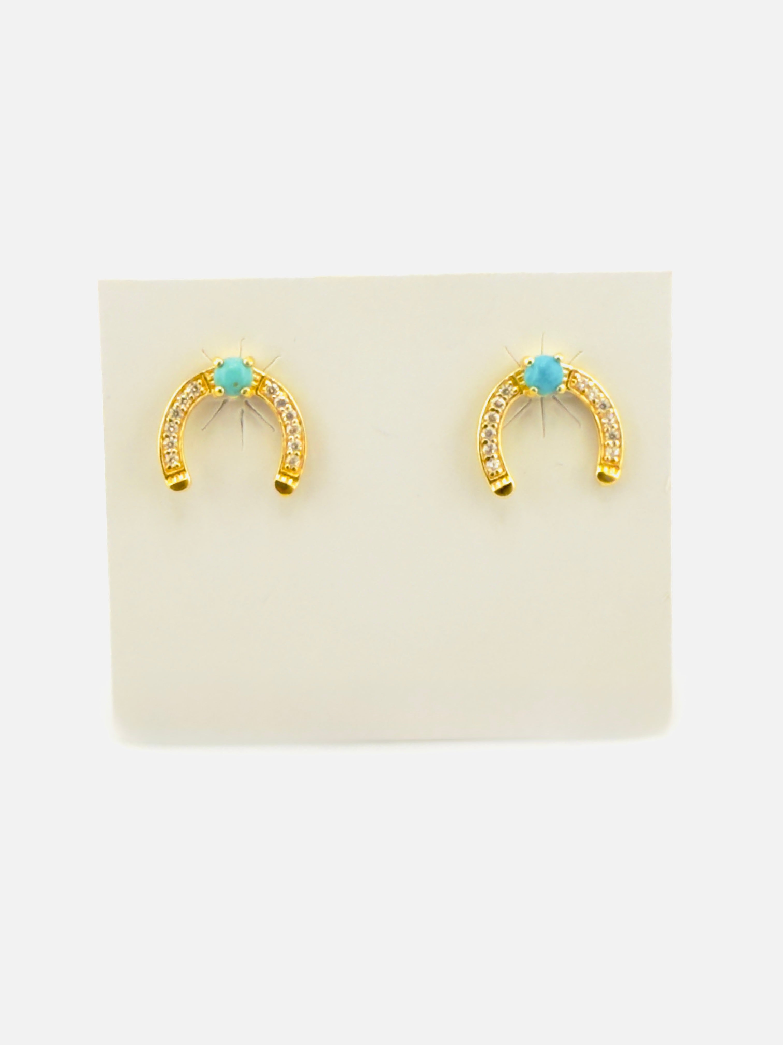 Gold horseshoe earrings with turquoise stones on a beige card