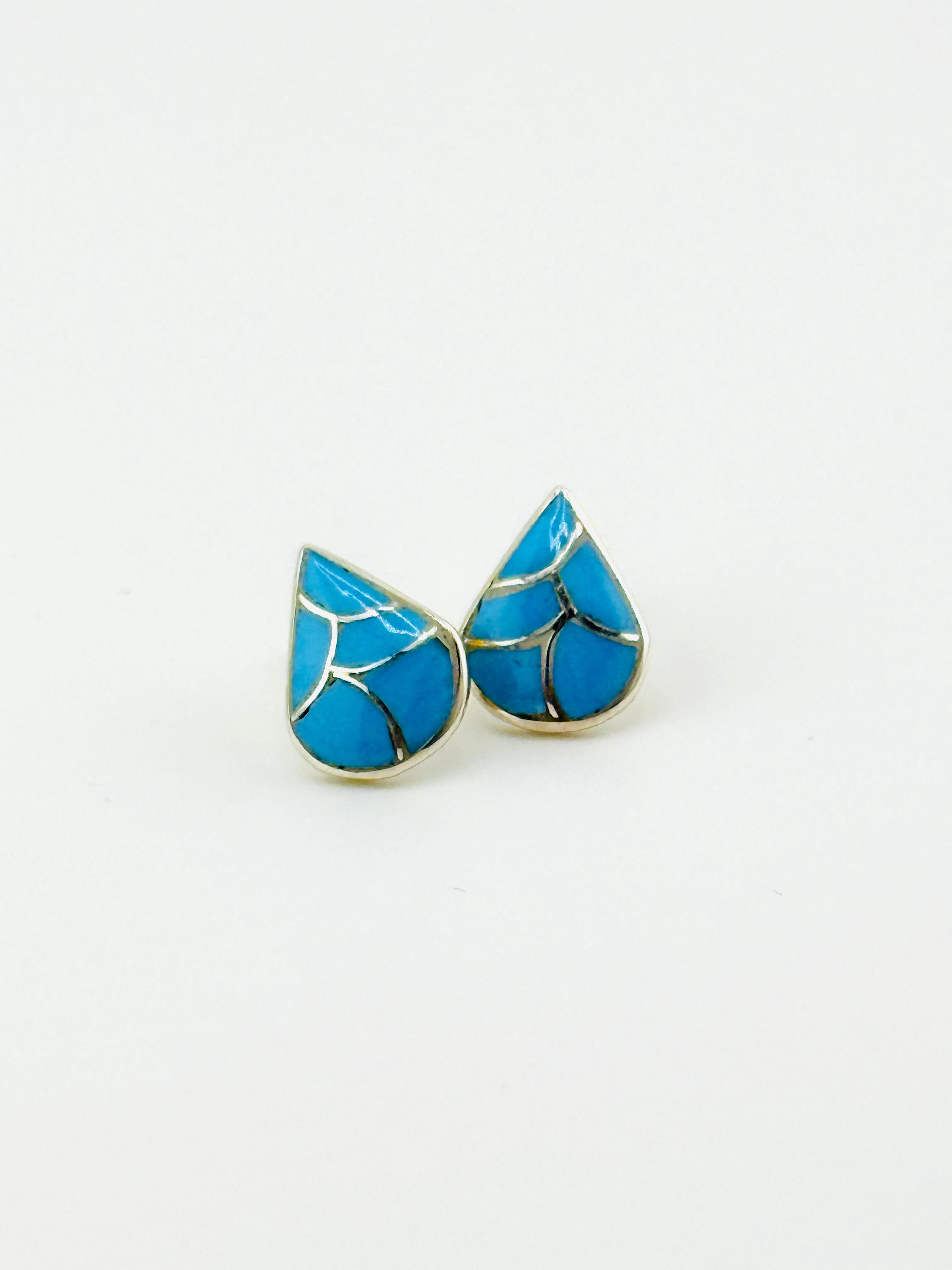 Blue teardrop-shaped earrings on a white background