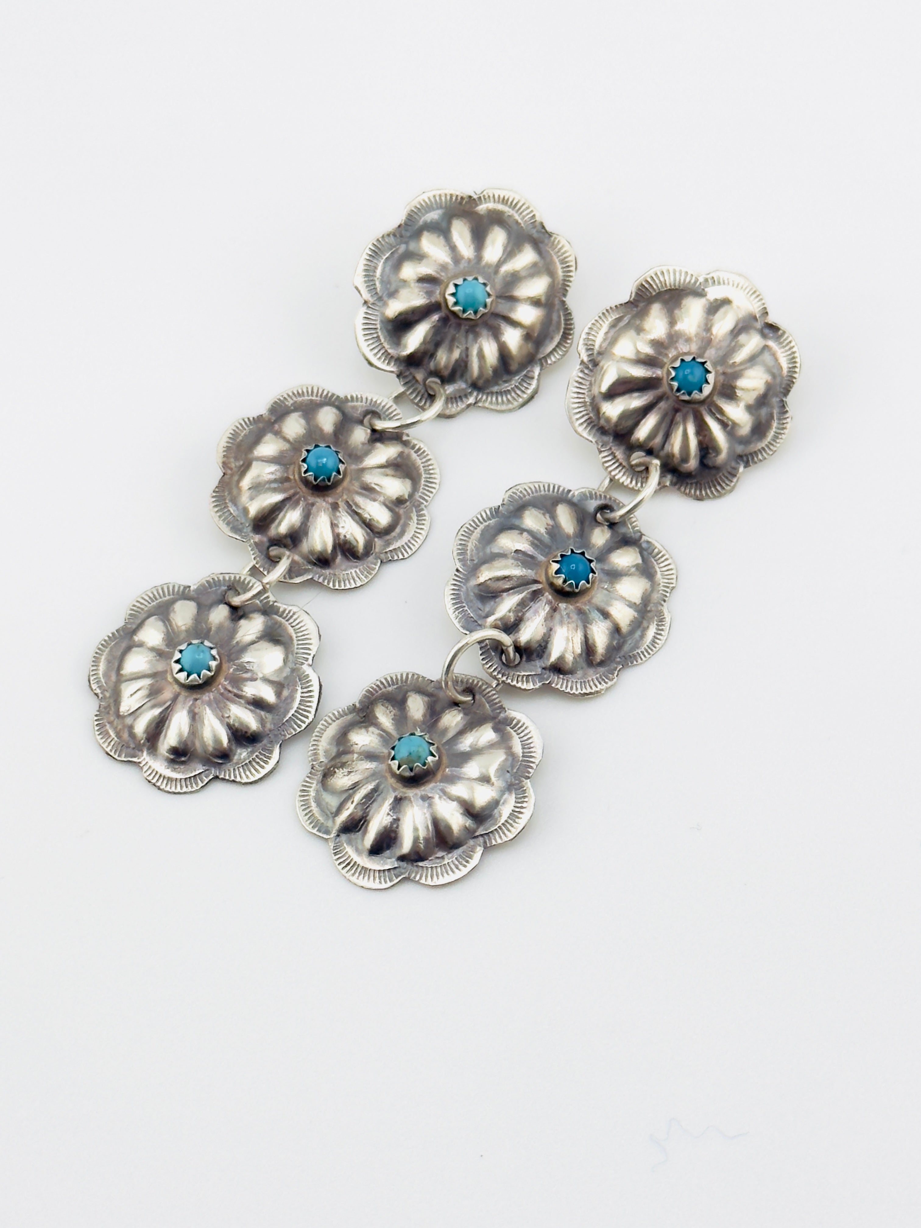 Silver floral earrings with blue turqoise on a white background