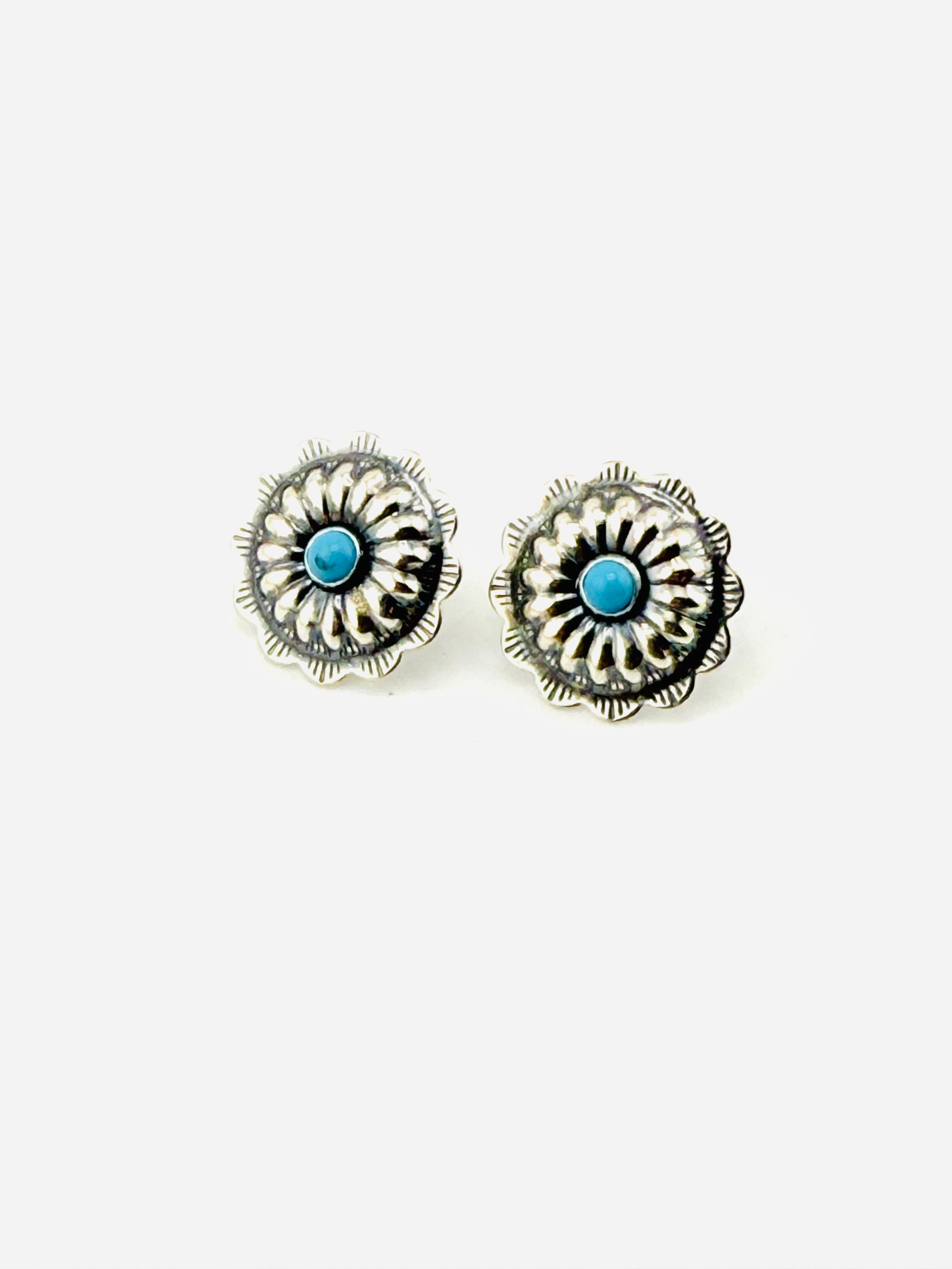 Pair of silver earrings with turquoise stones on a white background