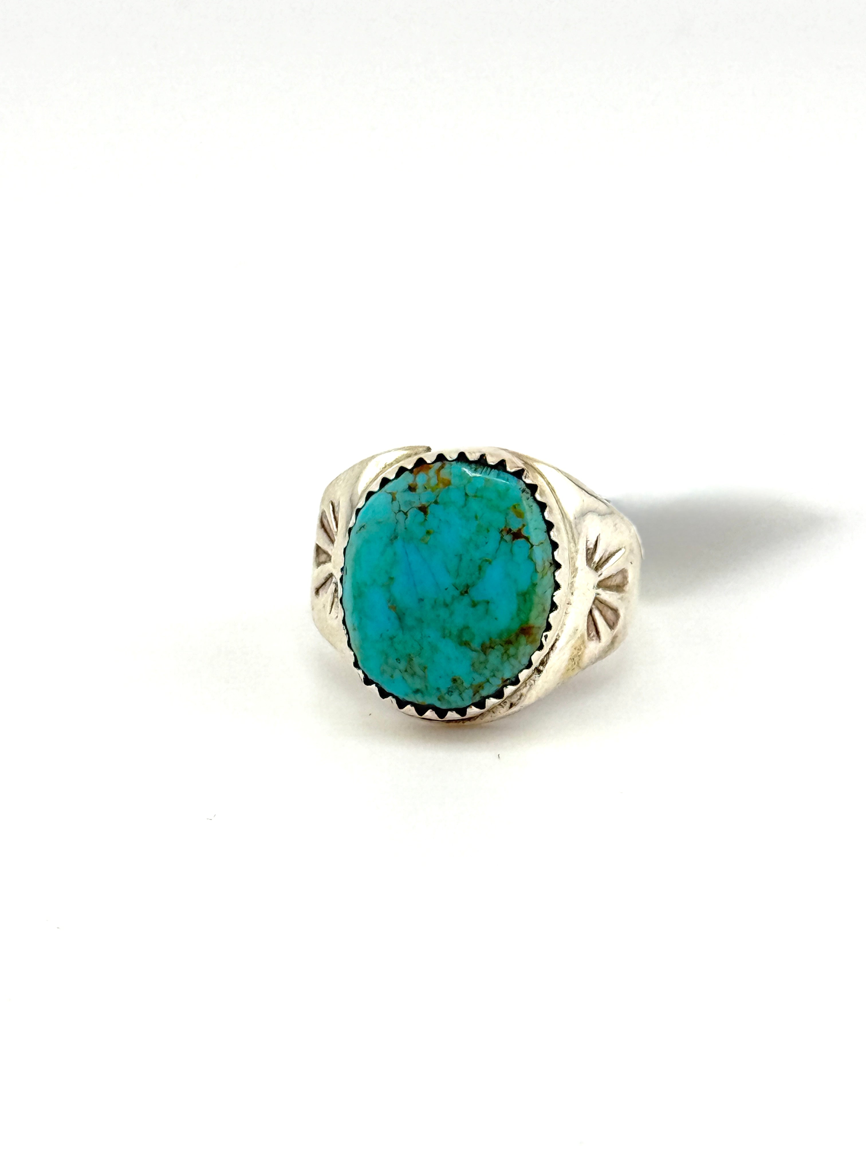 Turquoise ring with gold band on a white background