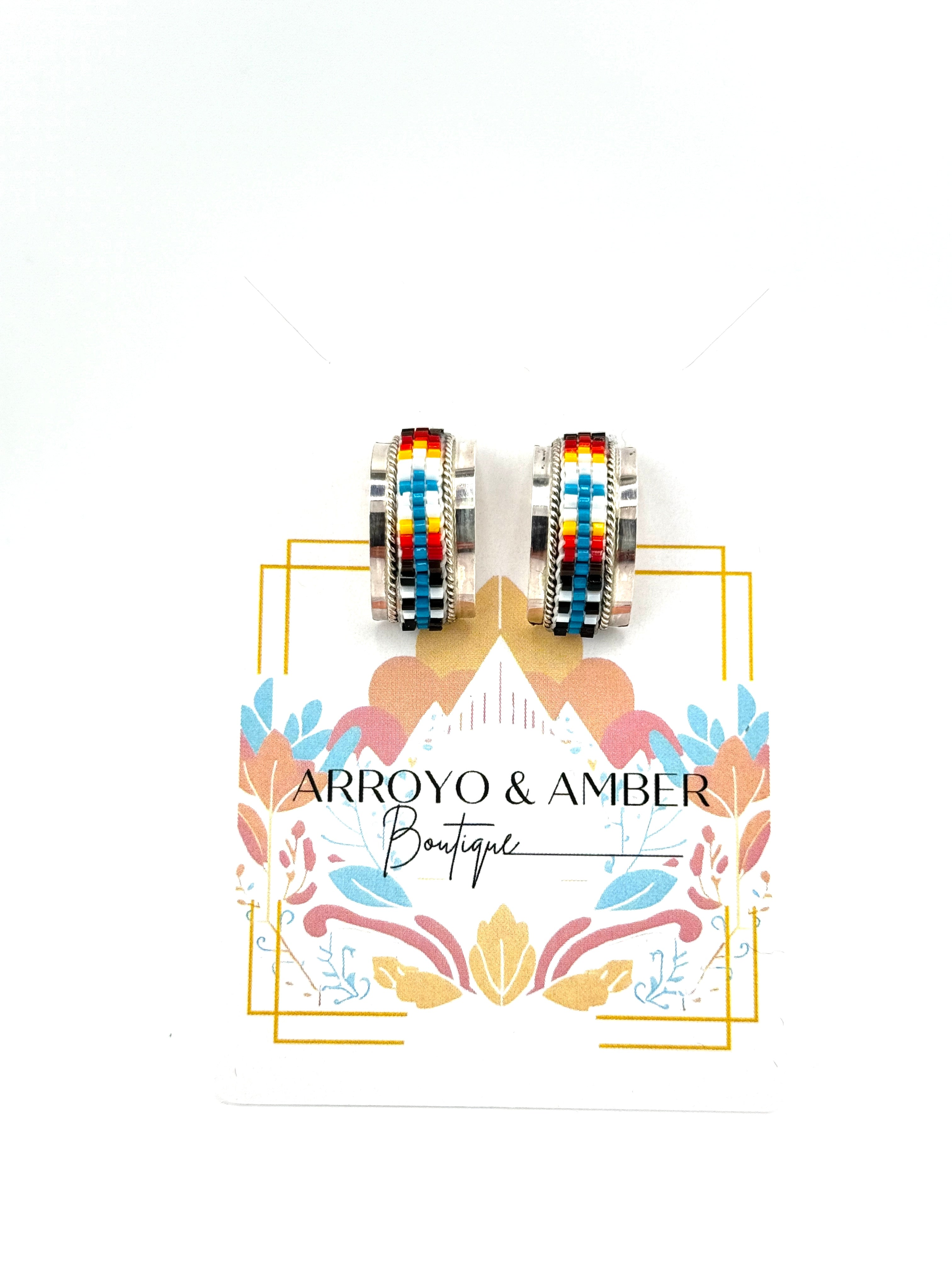 Colorful earrings on a branded card for Arroyo & Amber Boutique