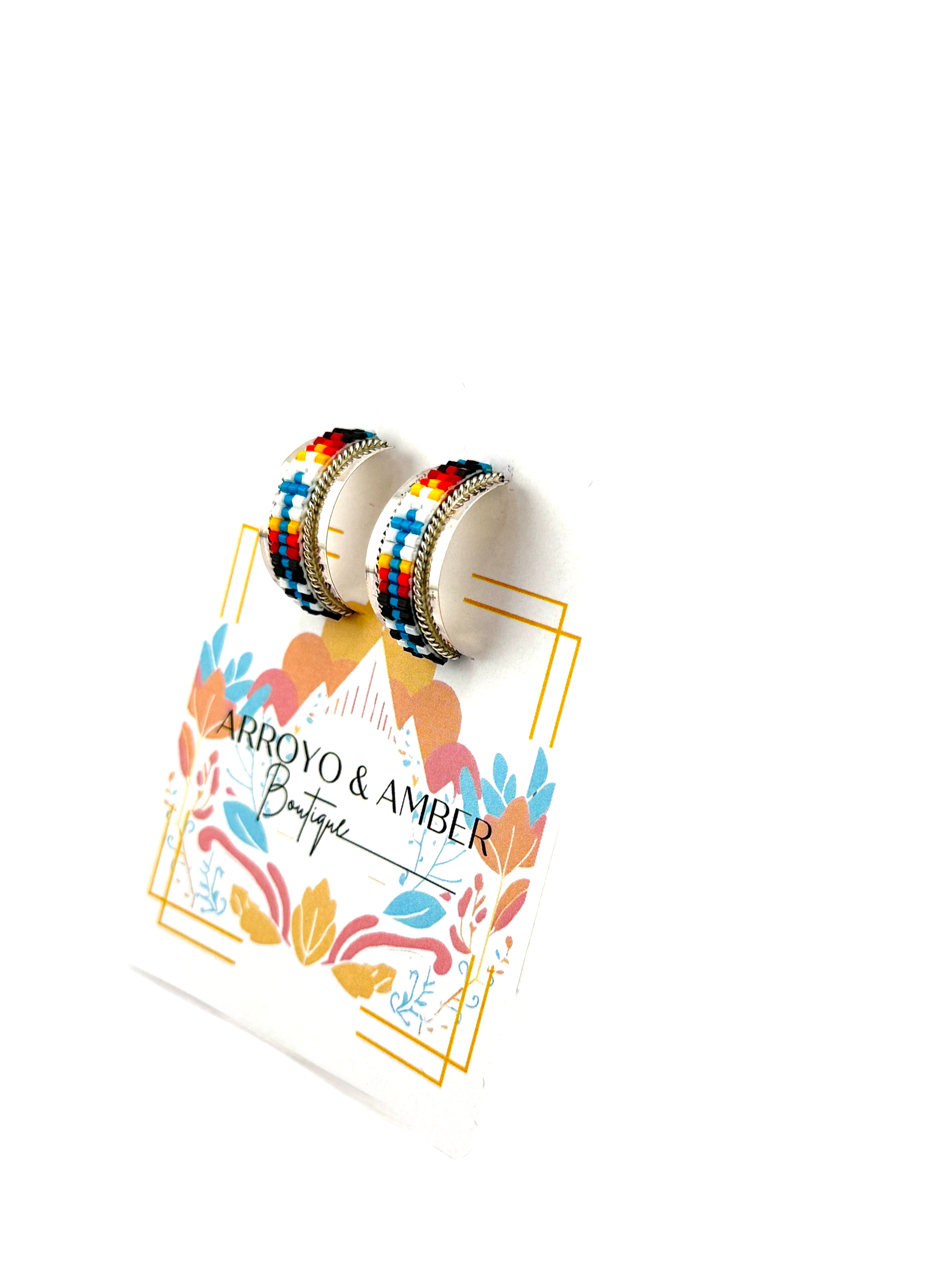 Colorful earrings on a branded card with 'Arroyo & Amber Boutique' design.