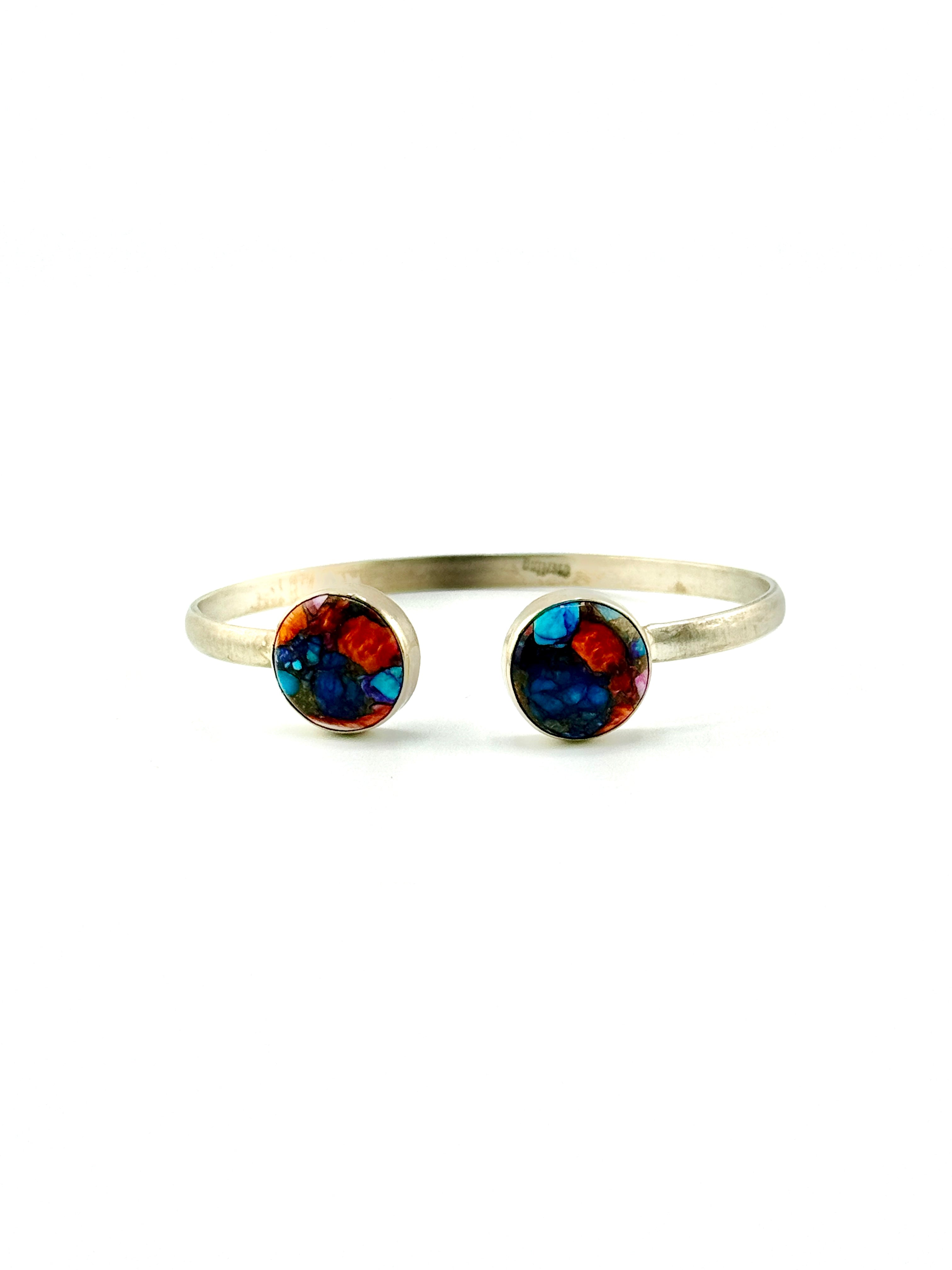 Silver ring with colorful gemstones on a white background
