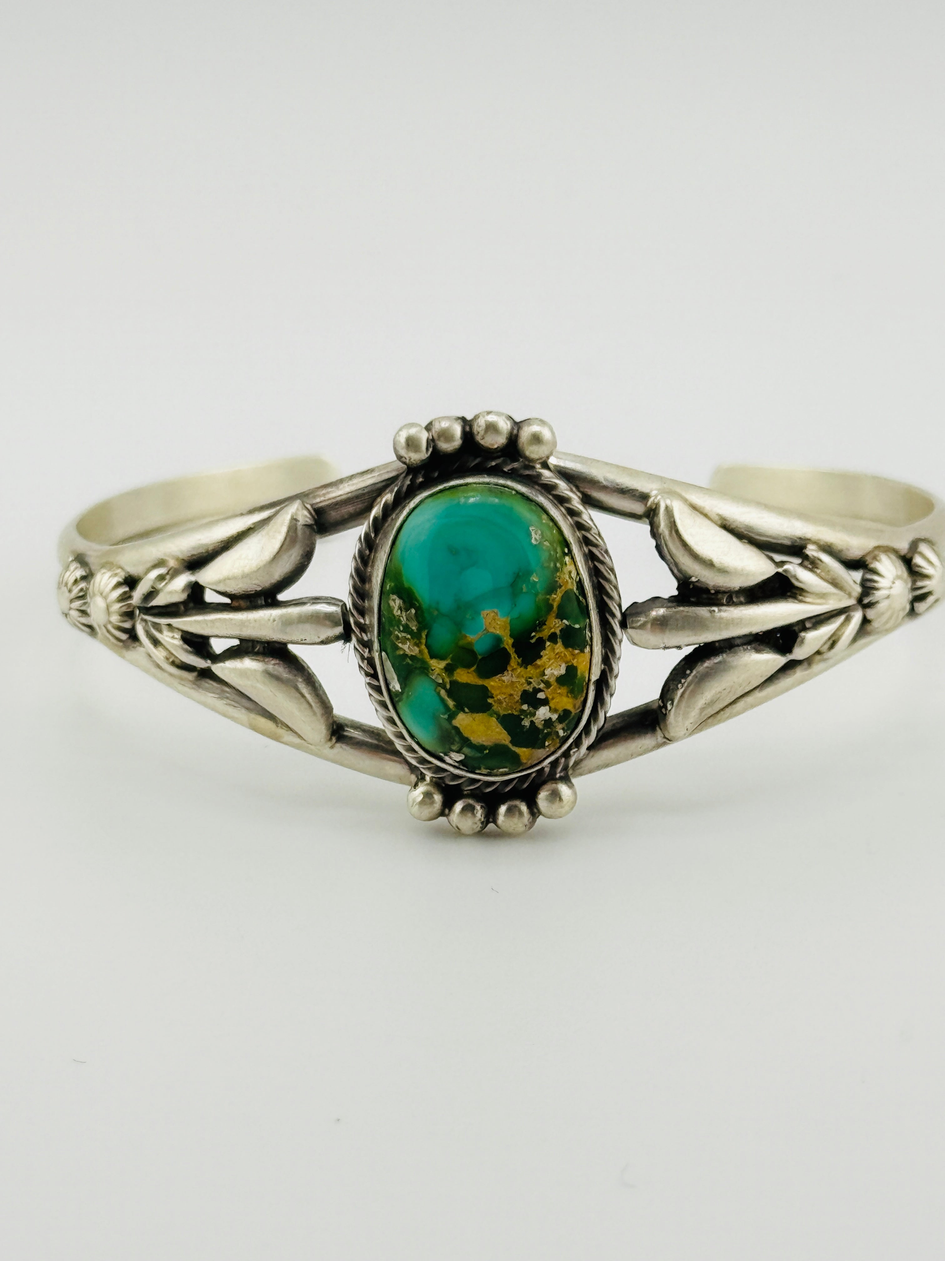 Silver bracelet with a turquoise stone on a white background