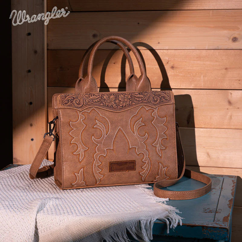 Brown leather handbag with intricate patterns on a wooden surface, featuring the Wrangler brand.