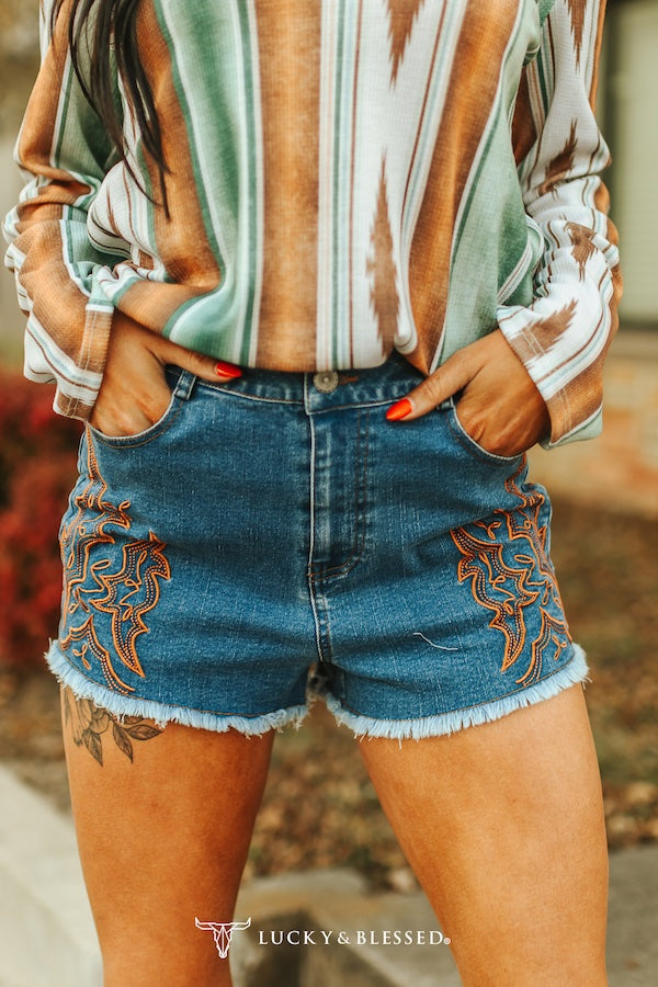Denim shorts with boot stitching and frayed hem on a woman's body