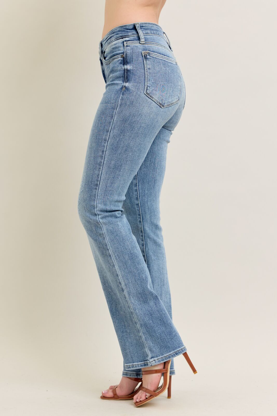 Light blue jeans worn by a person on a beige background