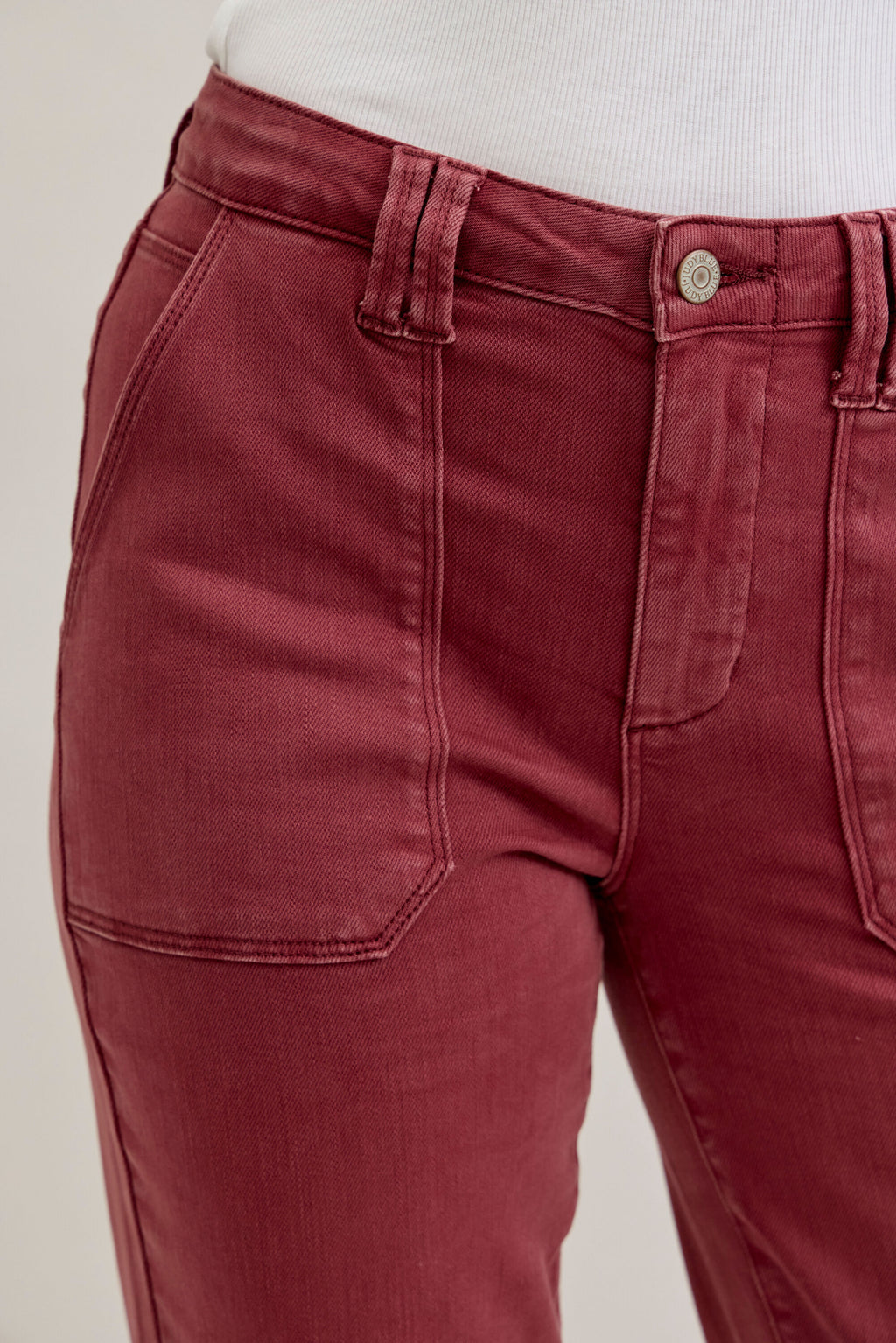 Maroon pants with a beige background