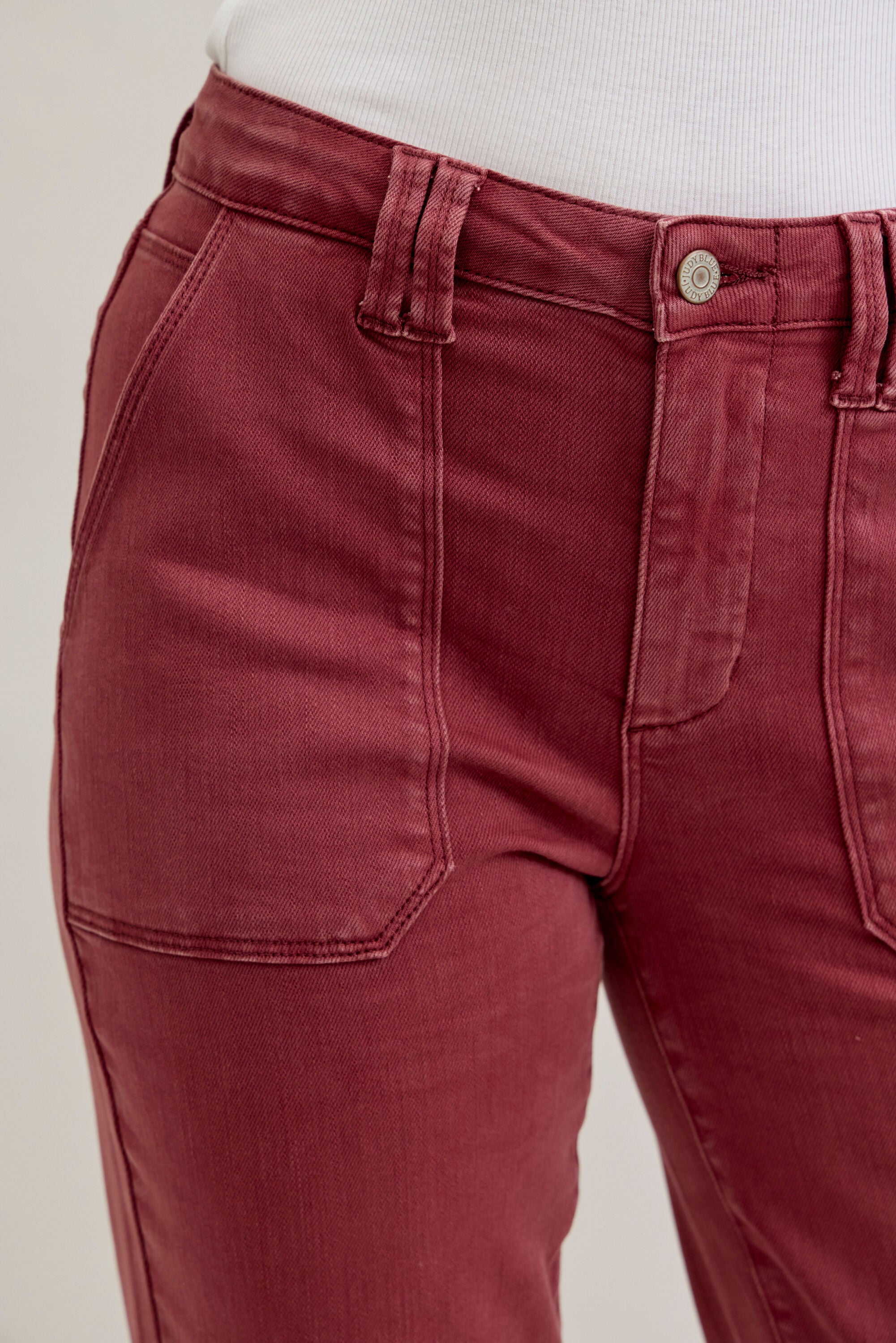 Maroon pants with a beige background