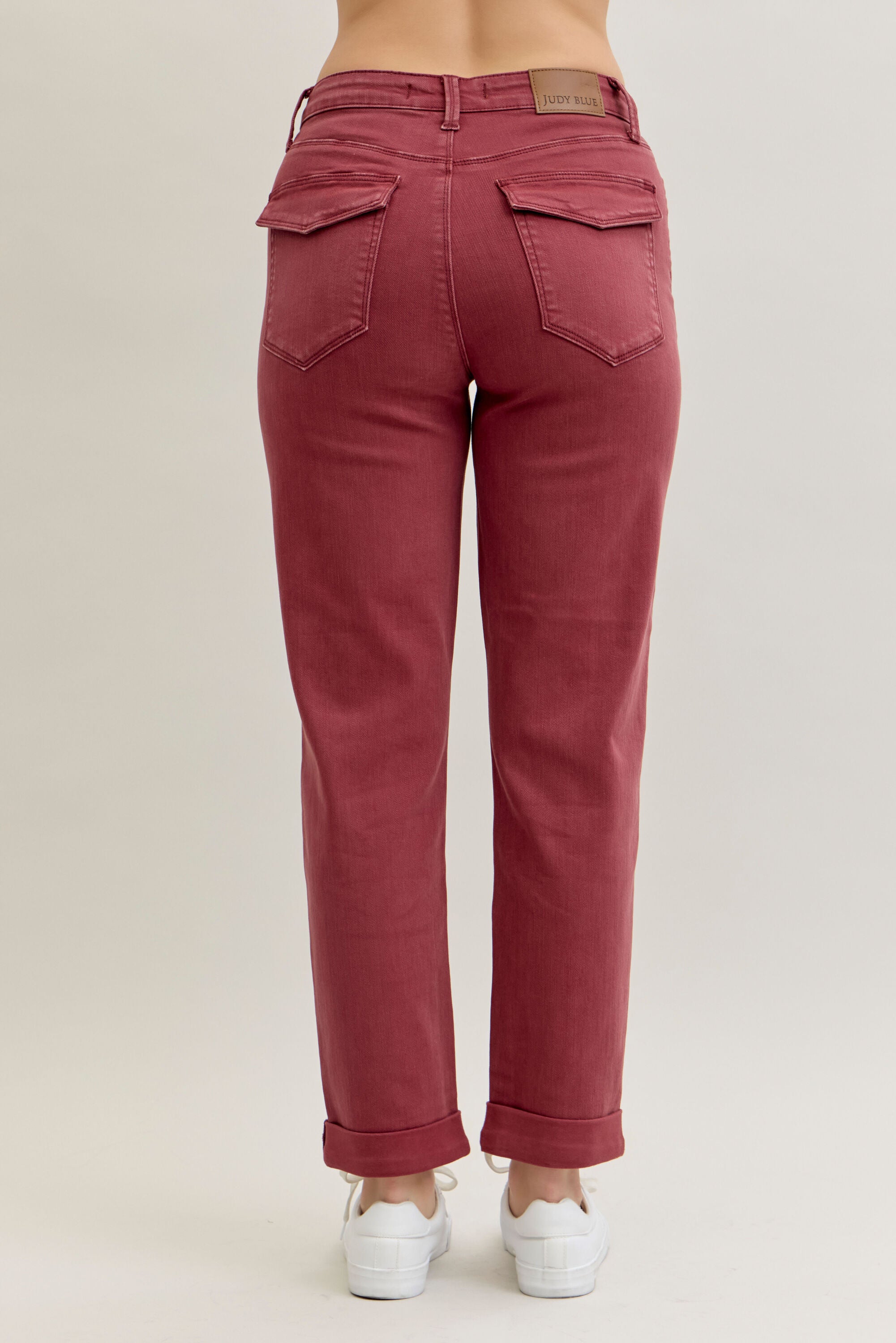 Red jeans worn by a person on a beige background