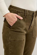Close-up of olive green pants with a plain background