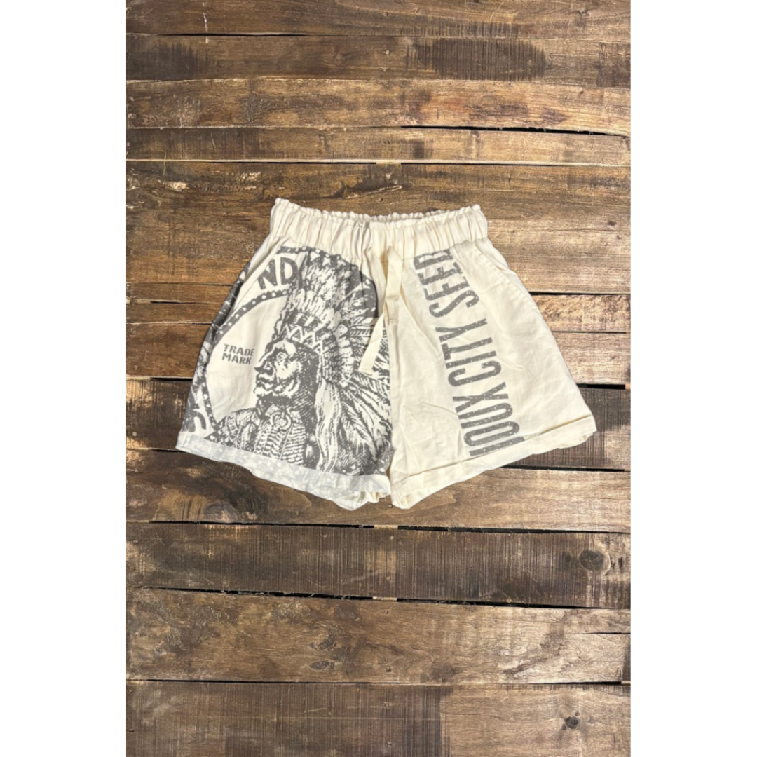 Beige shorts with graphic design on a wooden surface