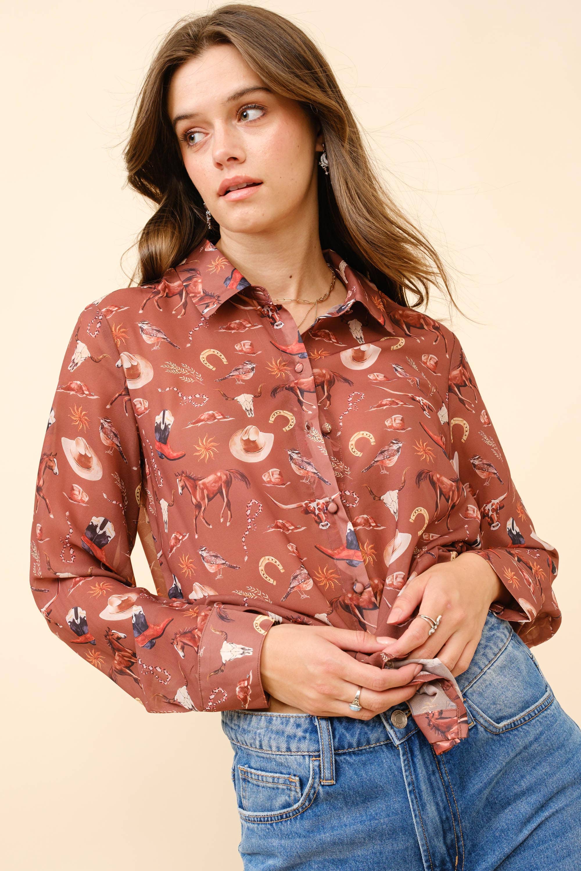 Woman wearing a patterned shirt and jeans on a beige background
