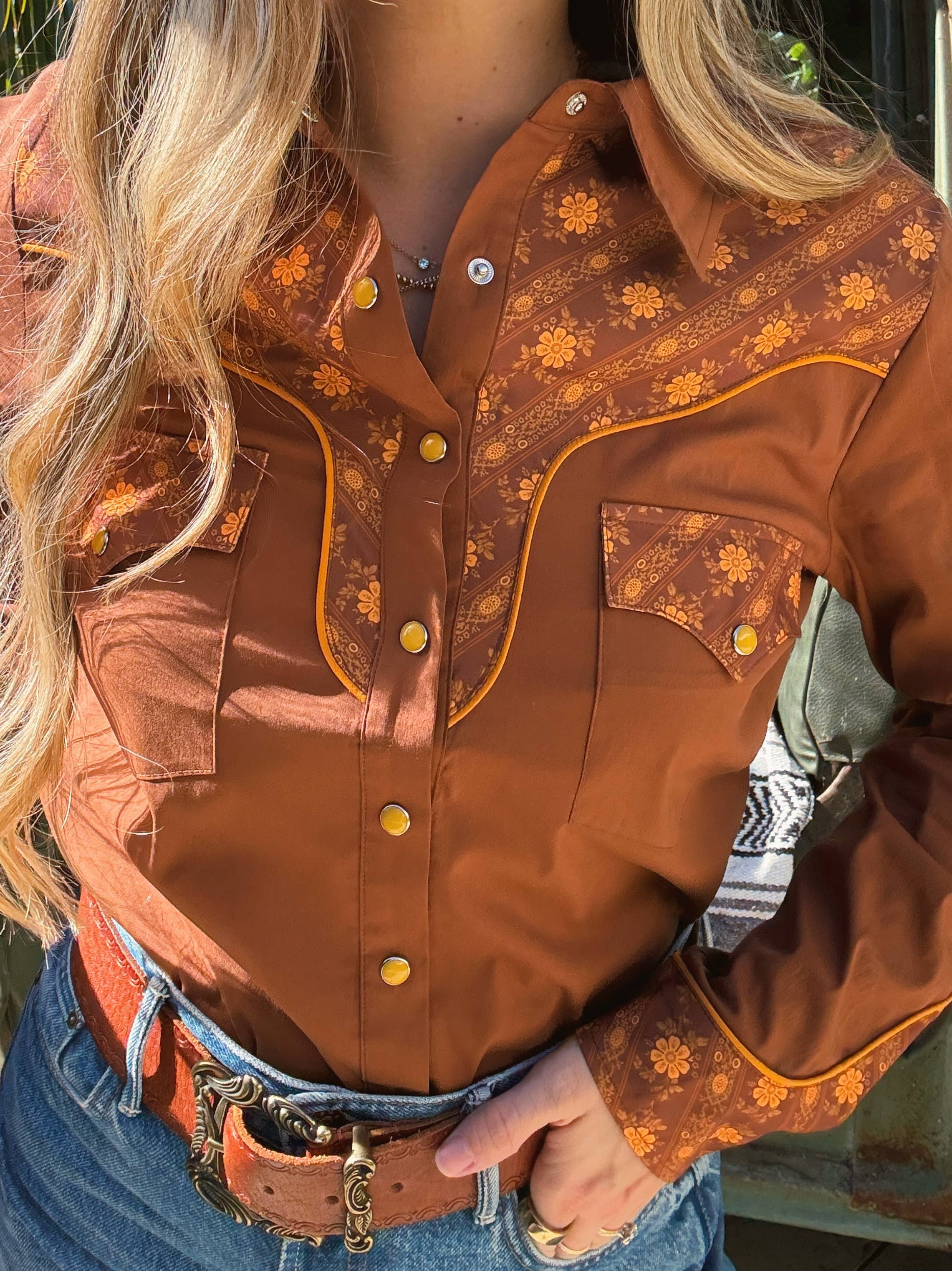 Brown embroidered shirt worn by a person with a blurred background
