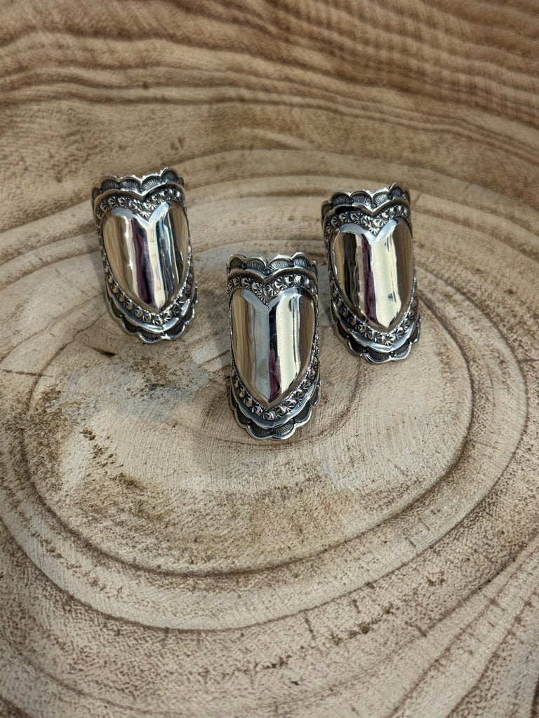 Set of three silver rings on a wooden surface
