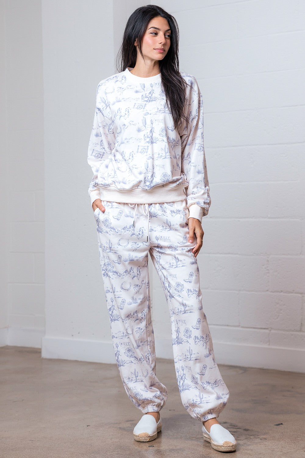 Woman wearing a white floral pajama set against a plain background