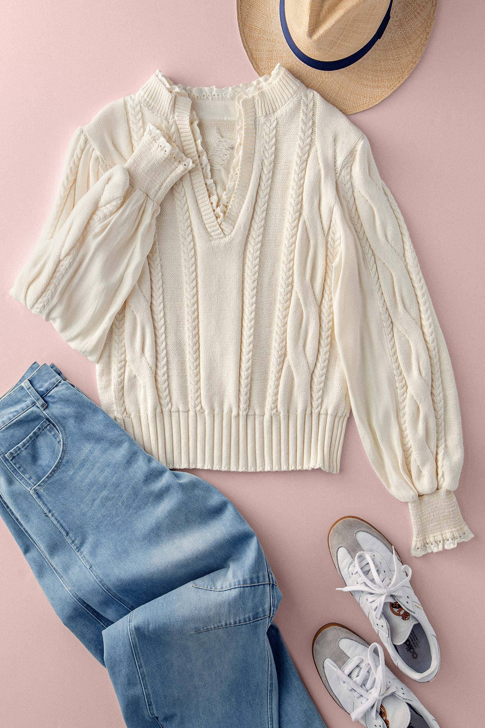 Cream sweater, blue jeans, white sneakers, and a straw hat on a pink background
