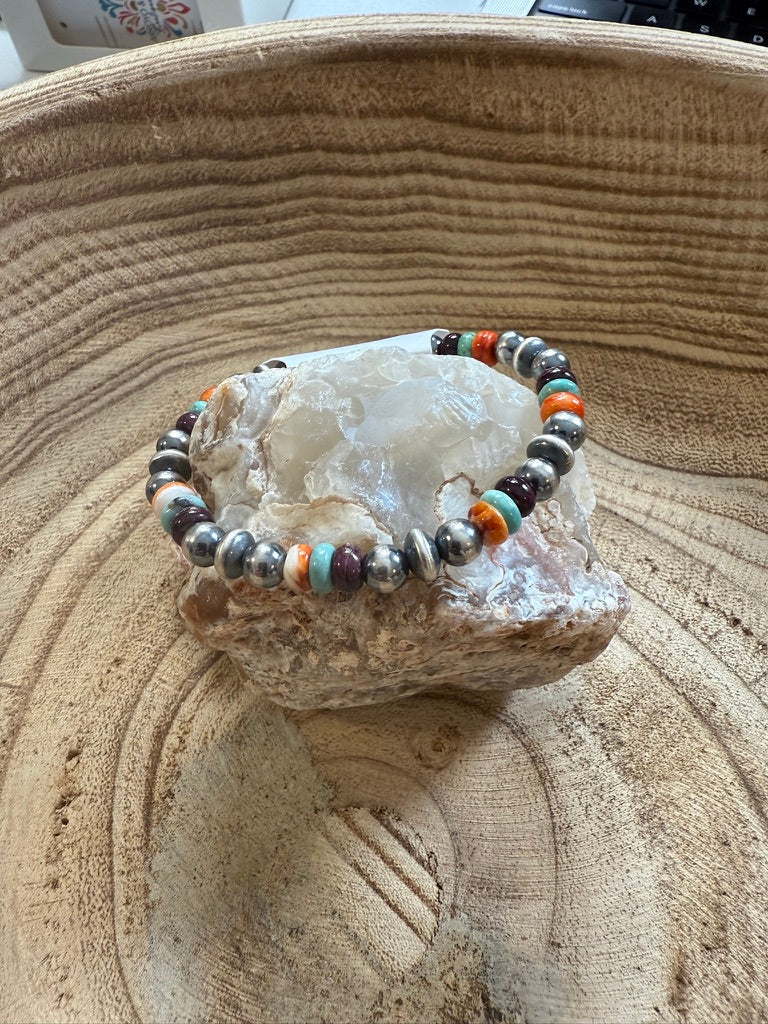 Multicolored beaded bracelet on a rock with a textured surface