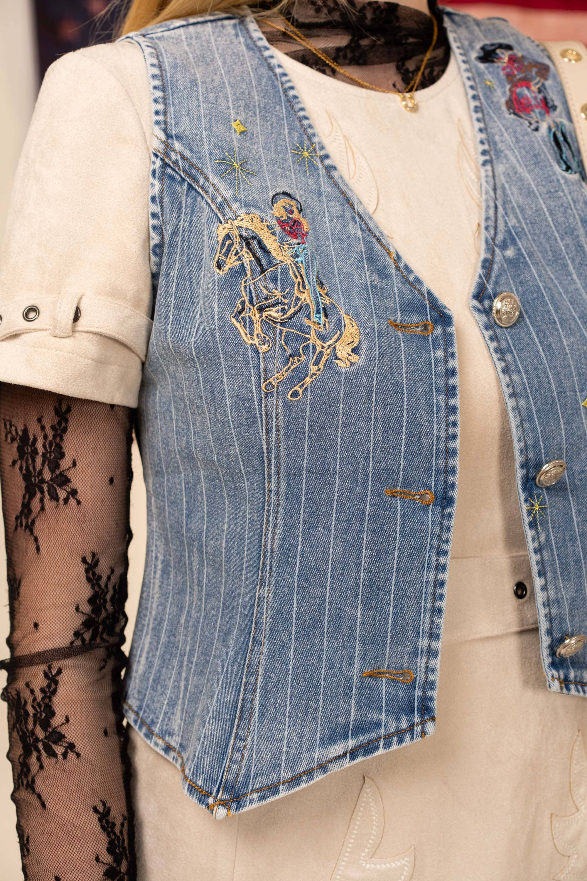 Denim vest with floral embroidery on a mannequin
