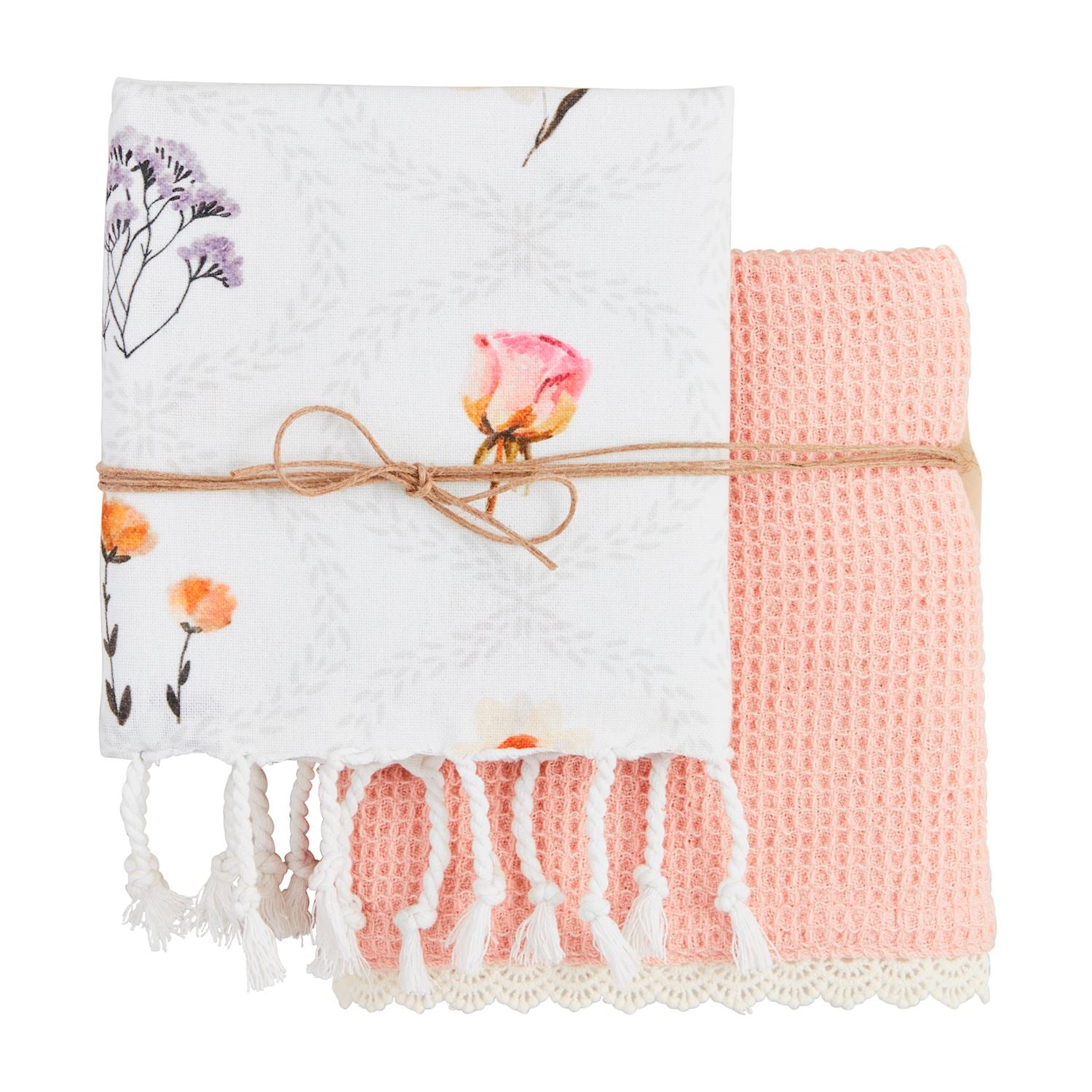 Two blankets, one floral and one pink waffle-textured, tied together with twine on a white background.