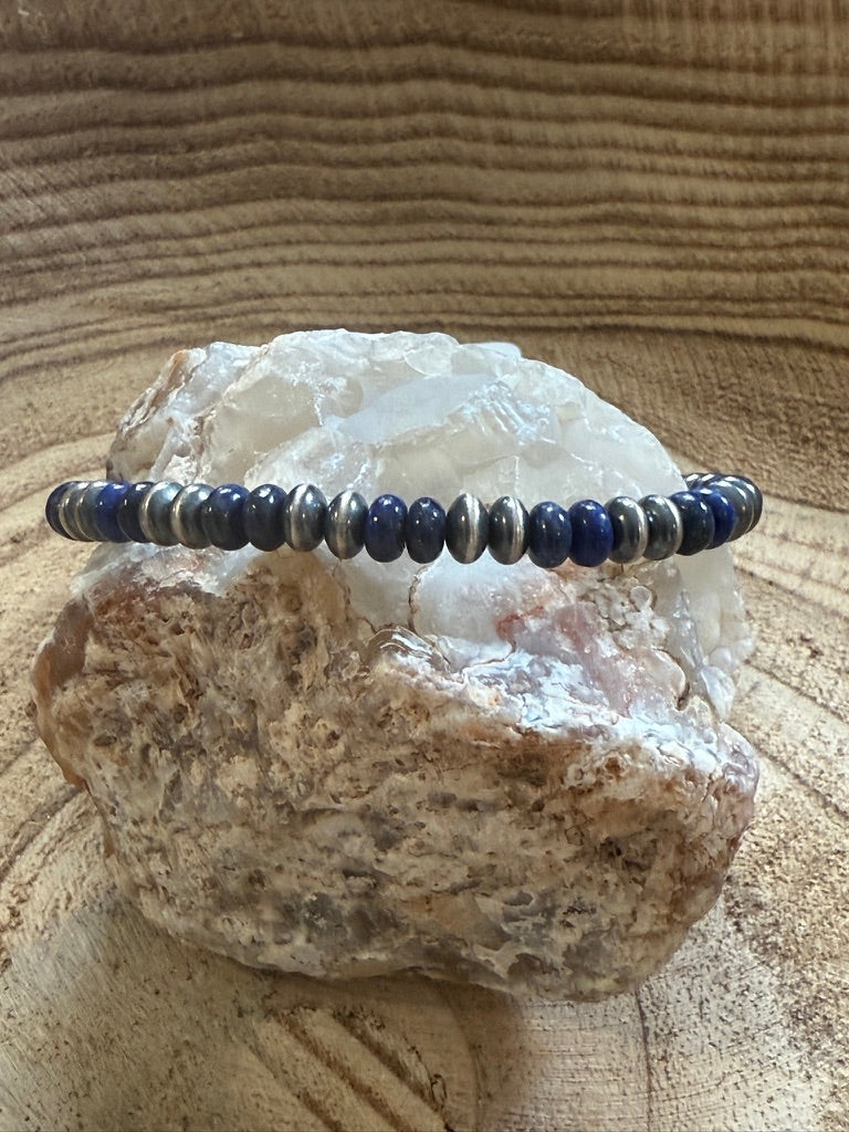 Beaded bracelet with blue and silver beads on a rock