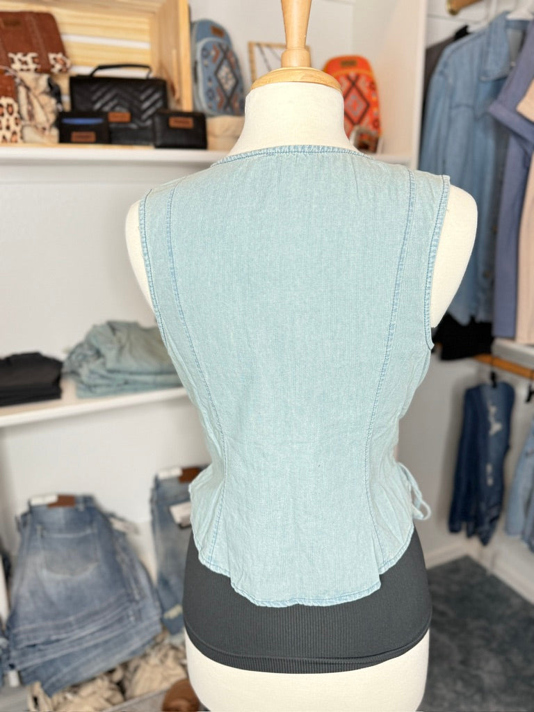 Light blue denim vest on a mannequin in a clothing store setting