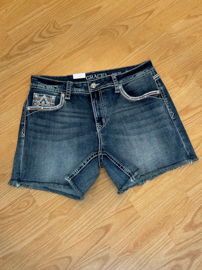 Blue denim shorts on a wooden floor with 'Grace' brand label.