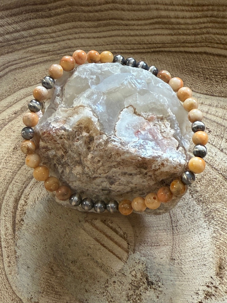 Decorative stone with a beaded bracelet on a wooden surface