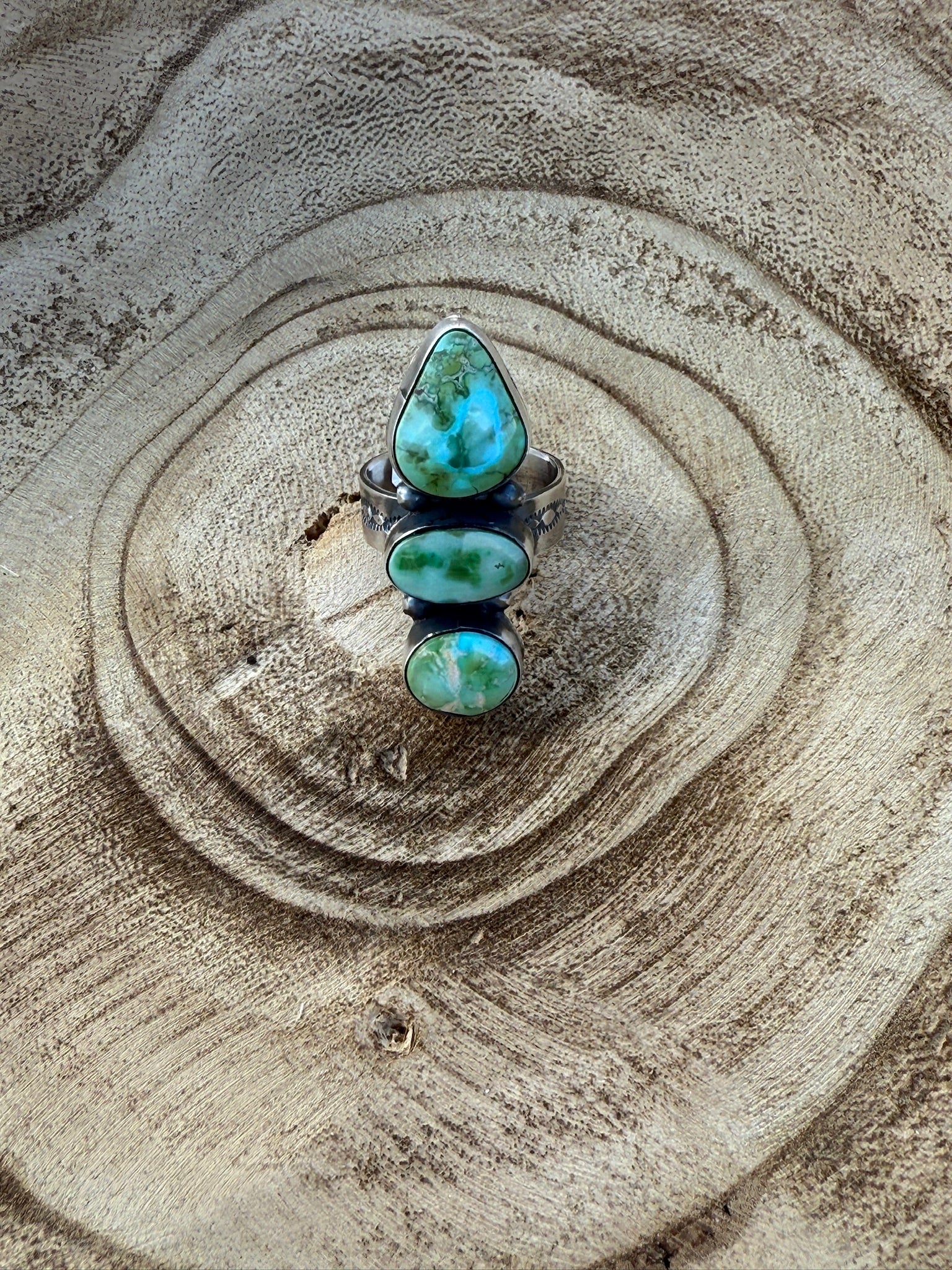 Turquoise ring on a textured sand surface