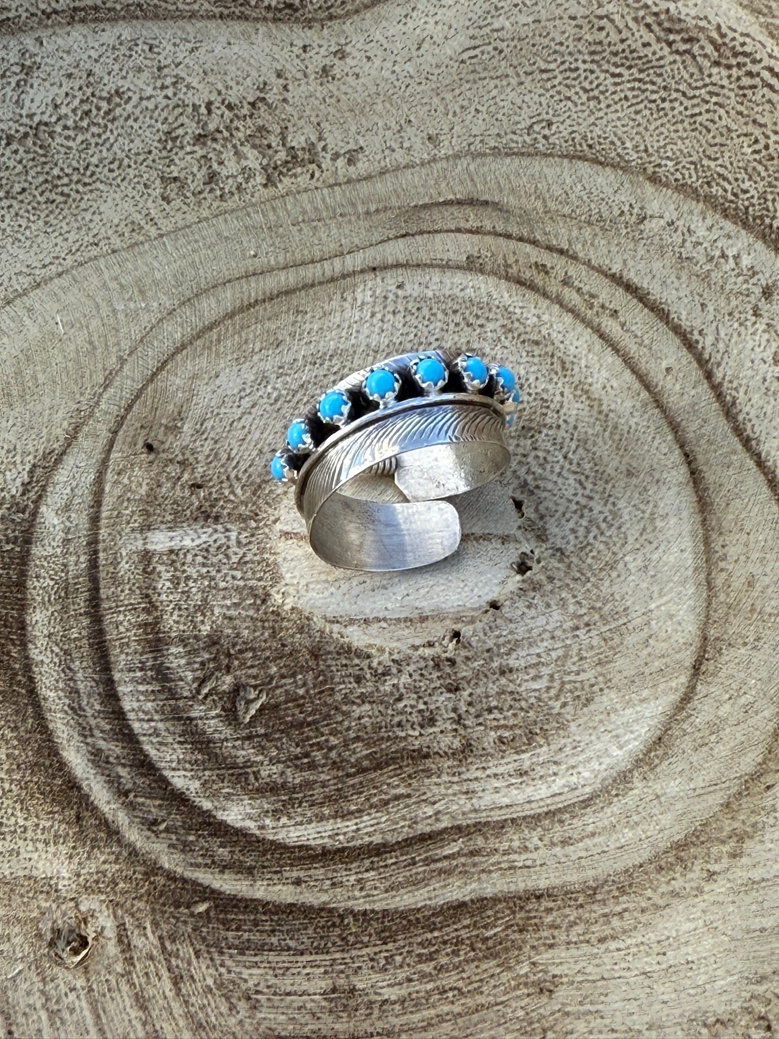Silver ring with blue stones on a wooden surface