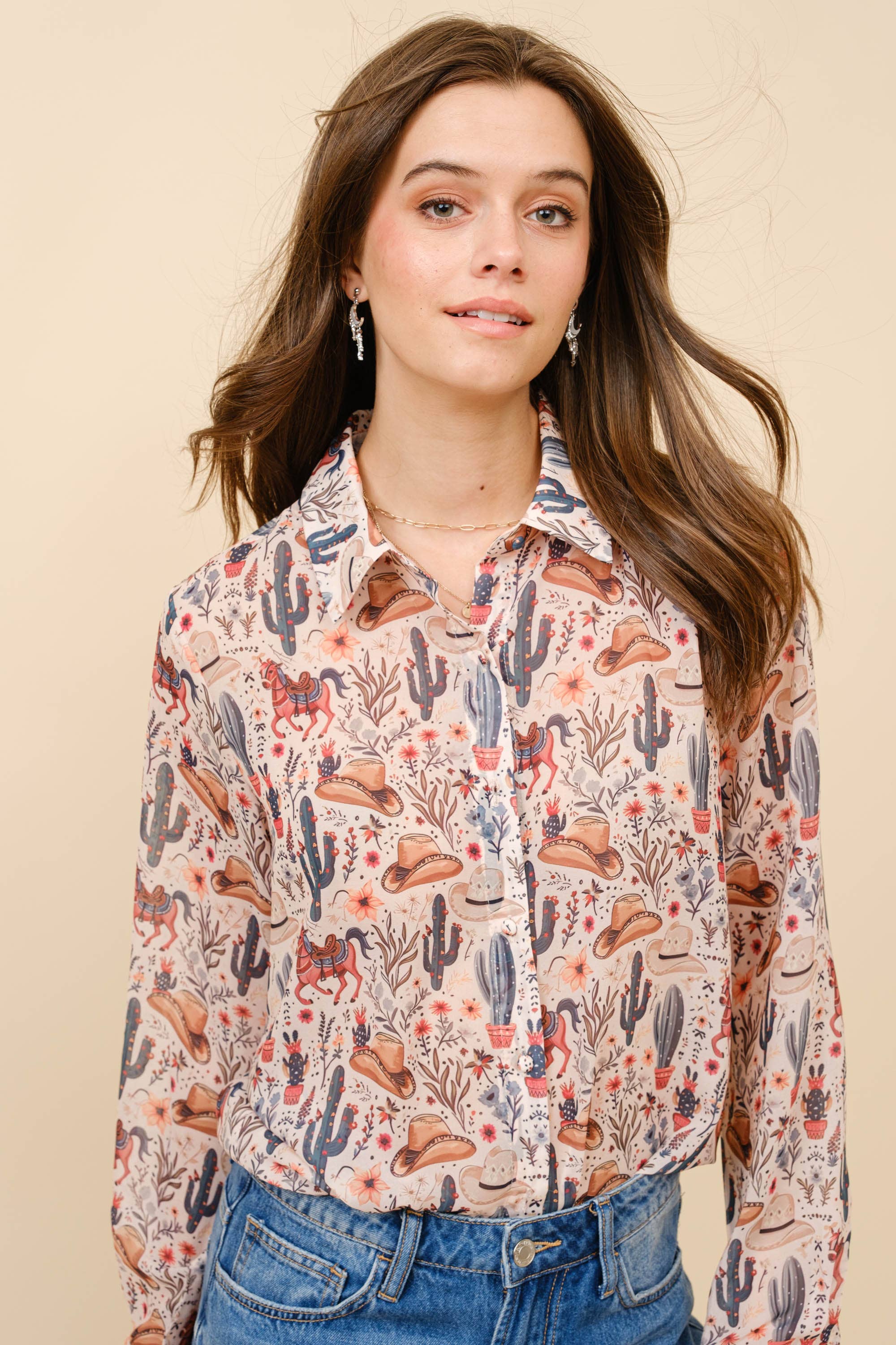 Woman wearing a patterned shirt with cacti and hats on a beige background