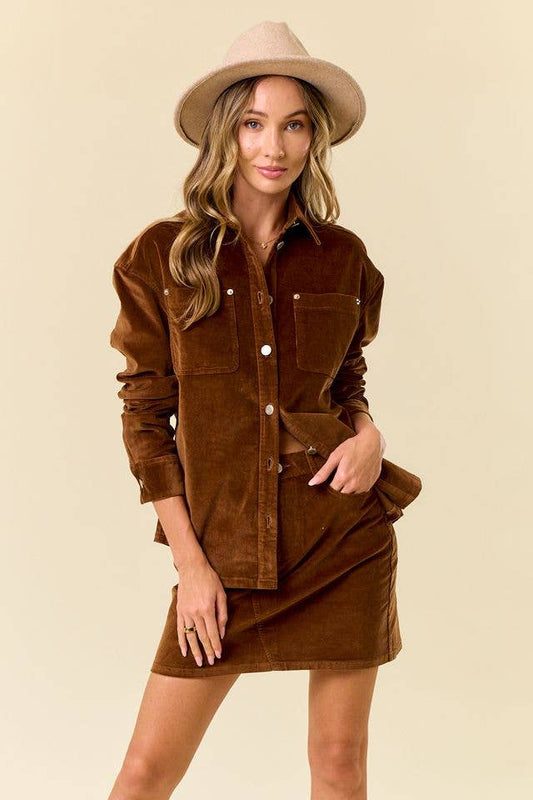 Woman wearing a brown corduroy dress and hat on a beige background