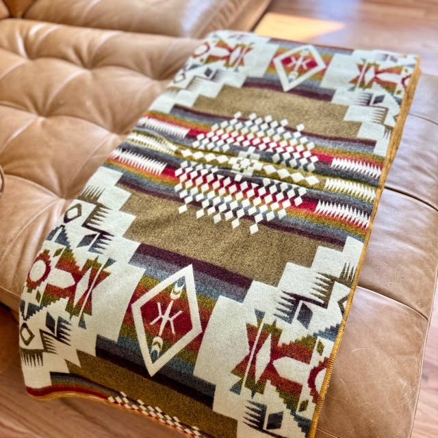 Decorative throw blanket with geometric pattern on a brown sofa