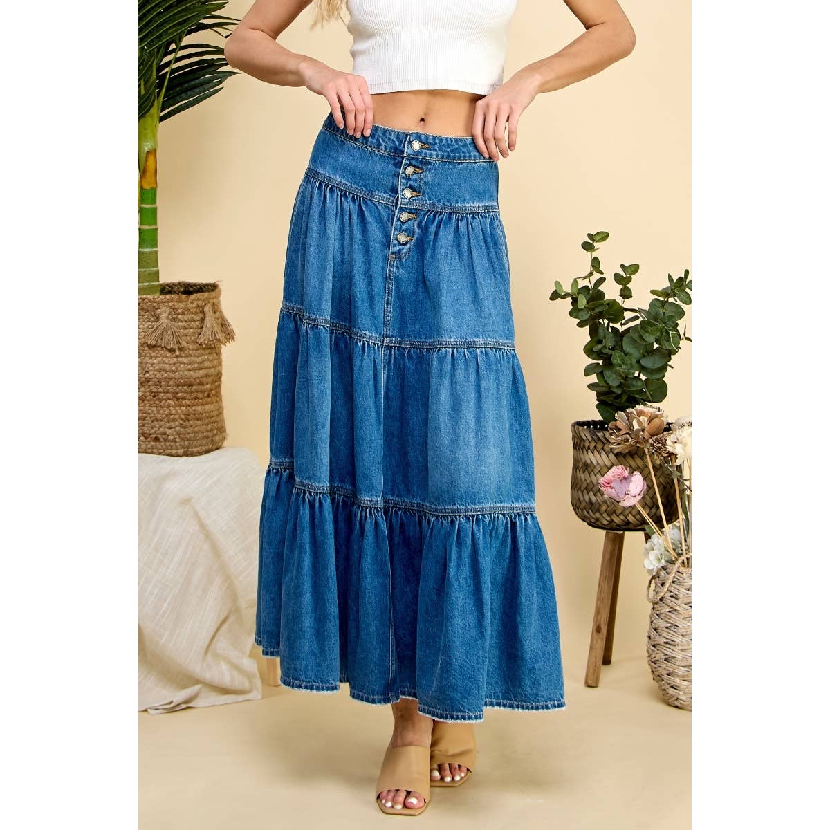 Woman wearing a blue denim skirt with a beige background