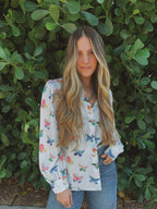 Woman wearing a floral blouse with a green leafy background