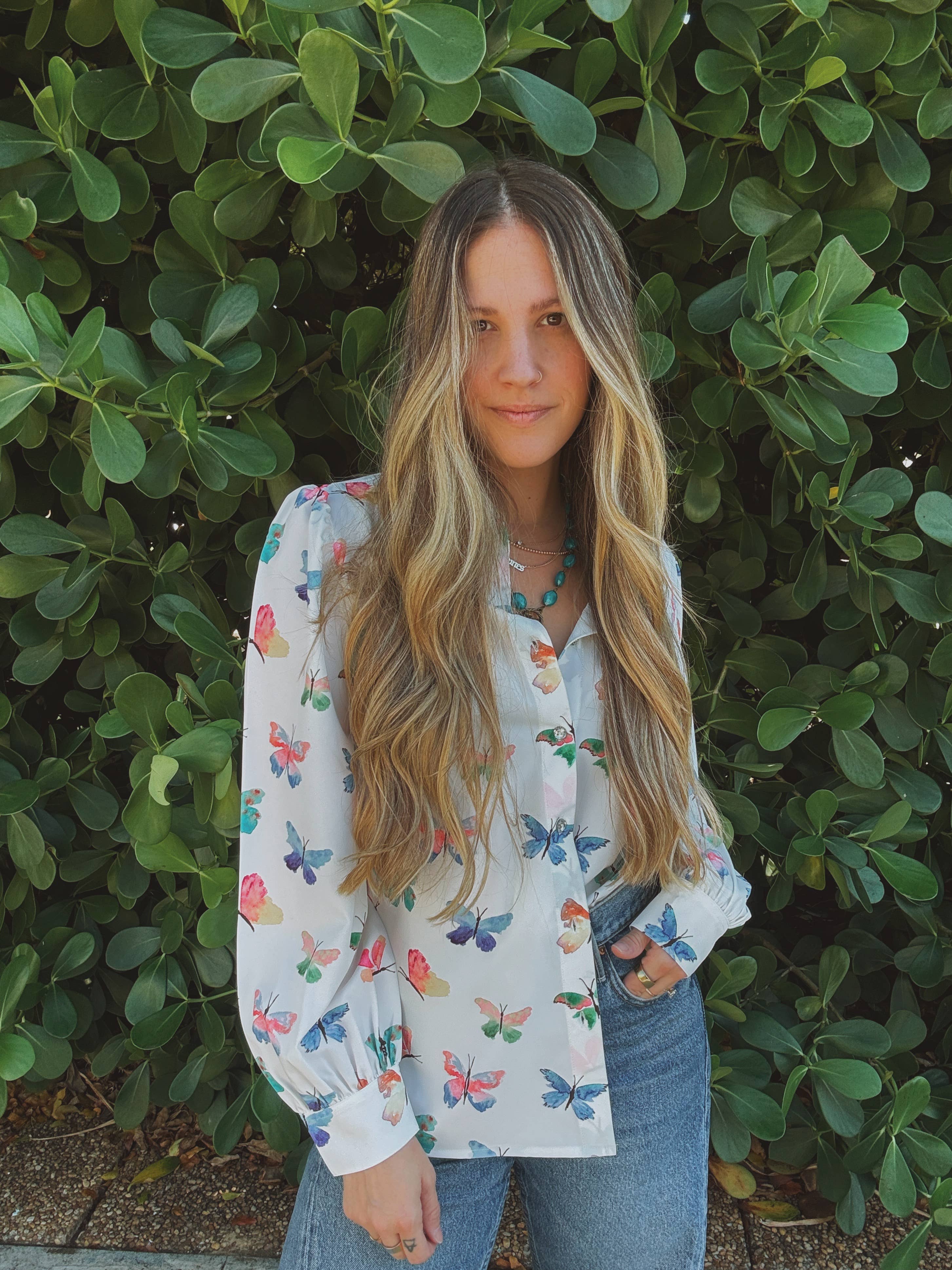 Woman wearing a floral blouse with a green leafy background