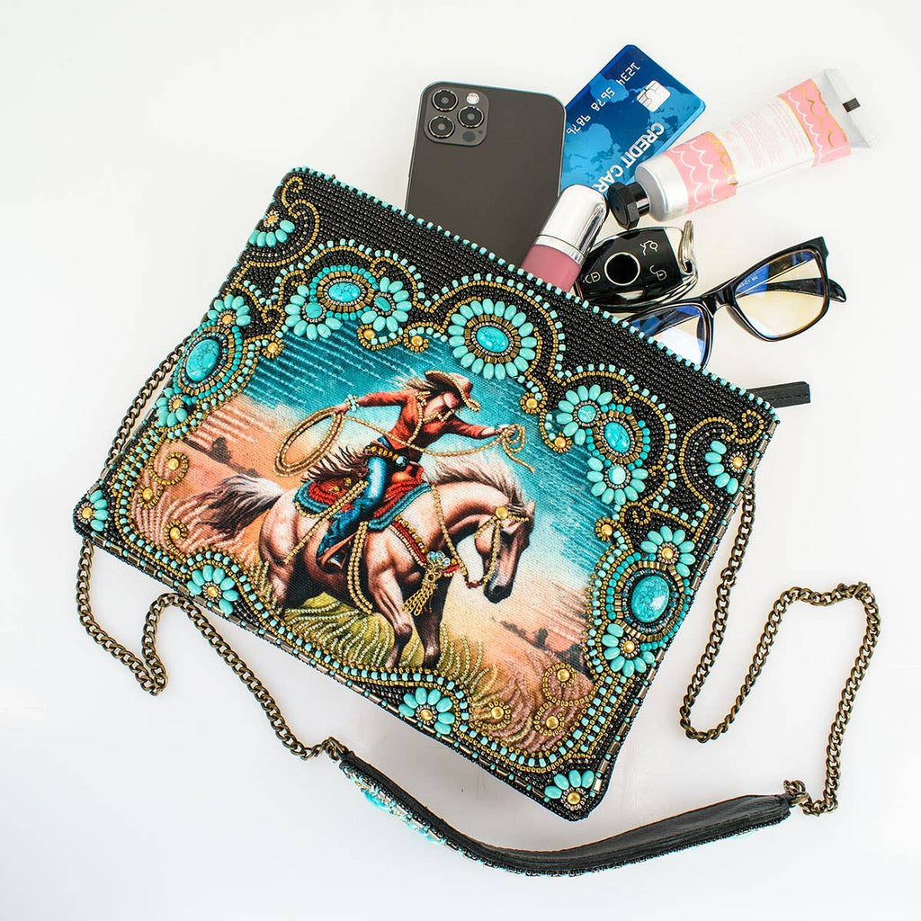 Decorative clutch bag with a cowboy design on a white surface