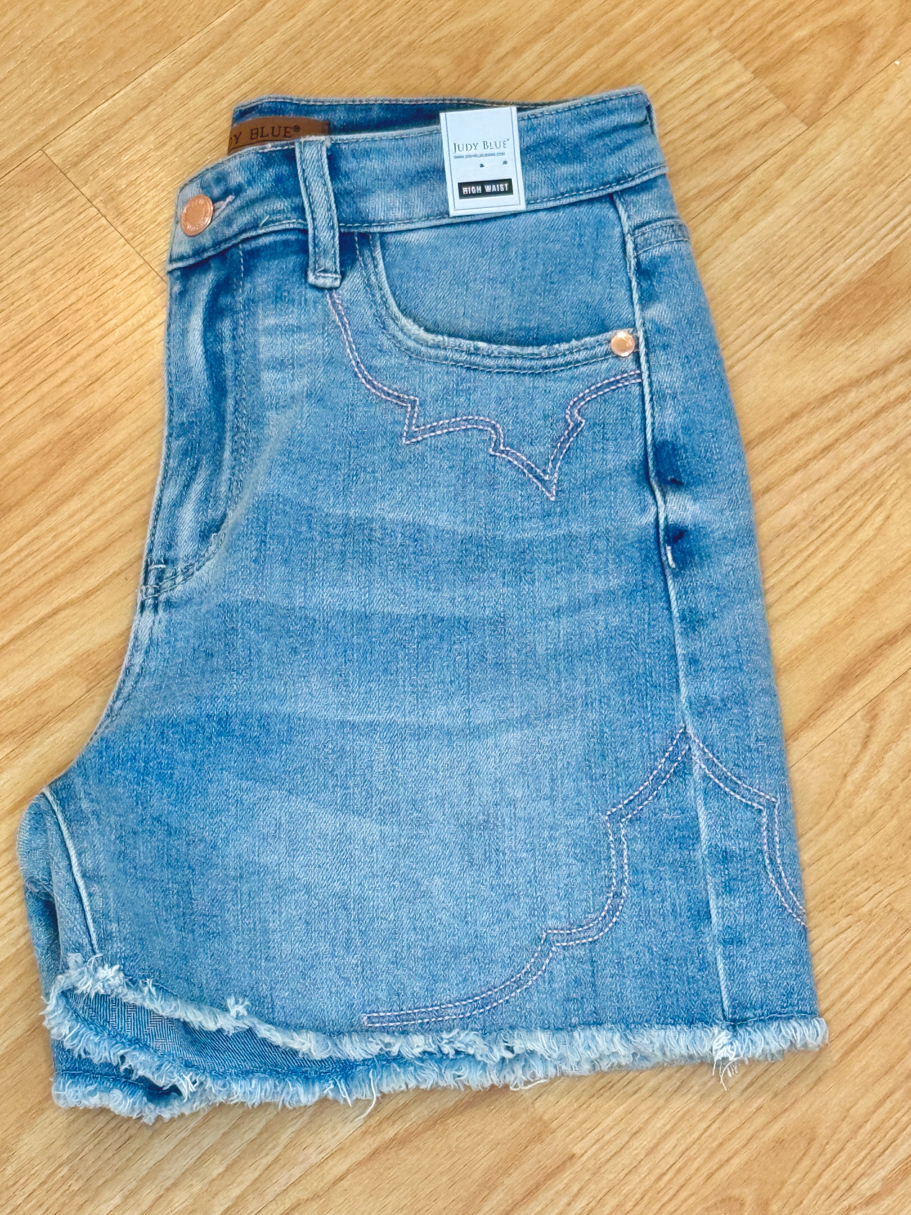 Pair of denim shorts on a wooden floor