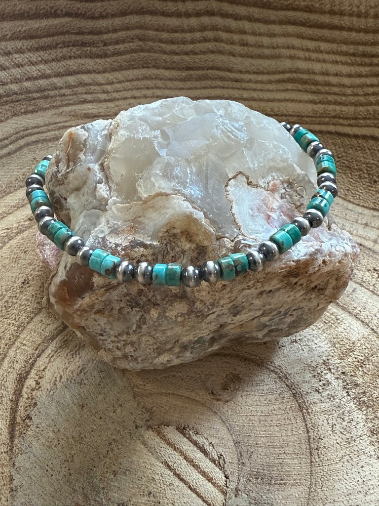 Turquoise and silver beaded bracelet on a large crystal with a textured surface