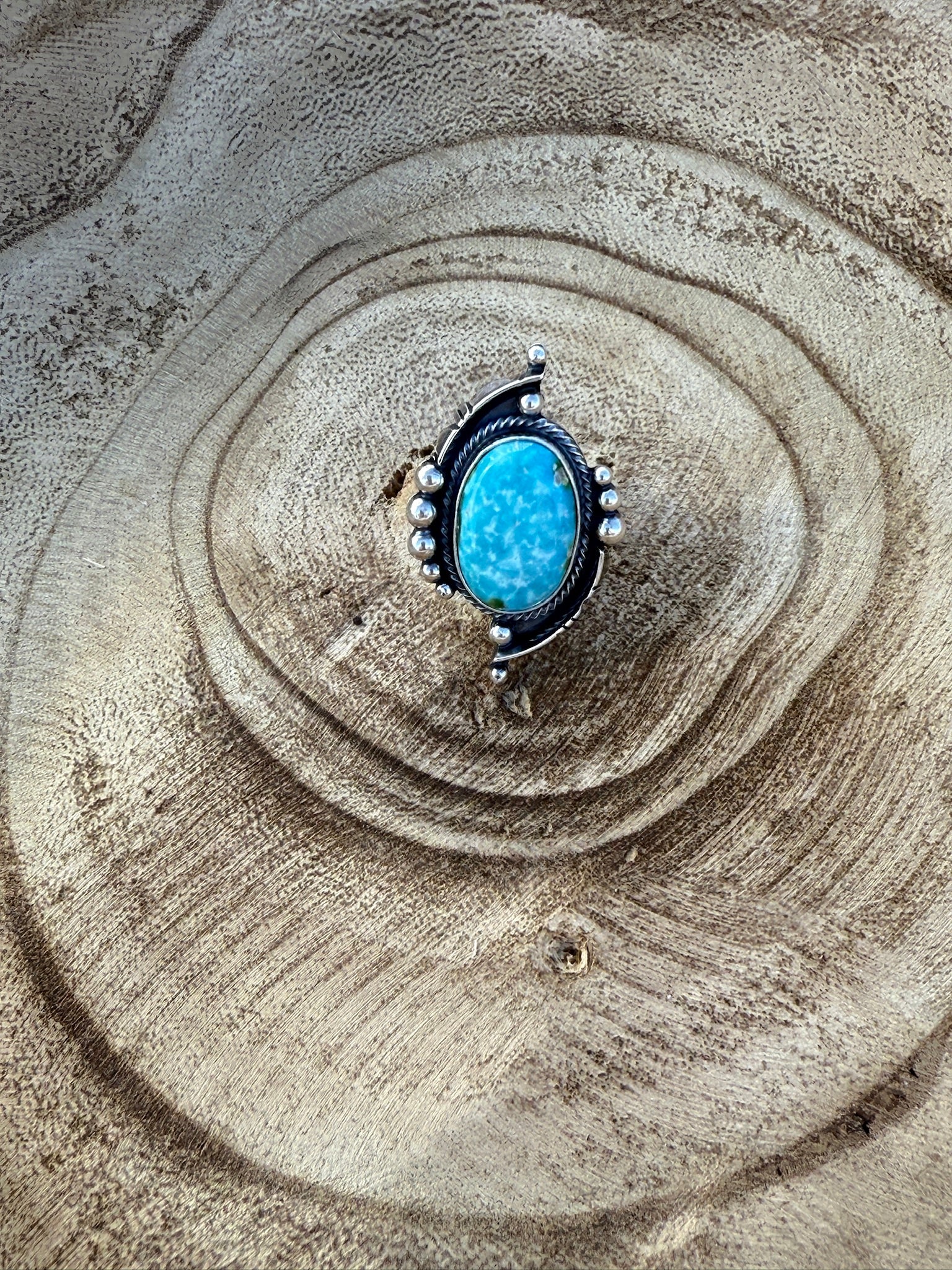 Ring with a blue stone on a textured sand surface